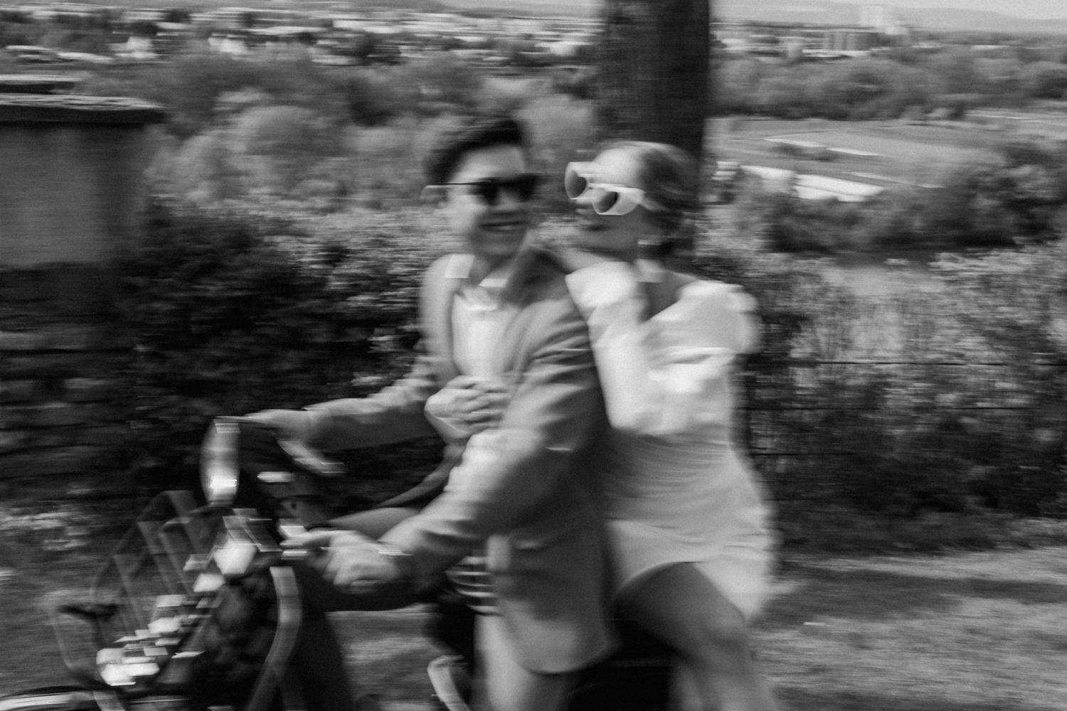 Vintage black and white photo of two people sharing a playful moment on a bicycle.