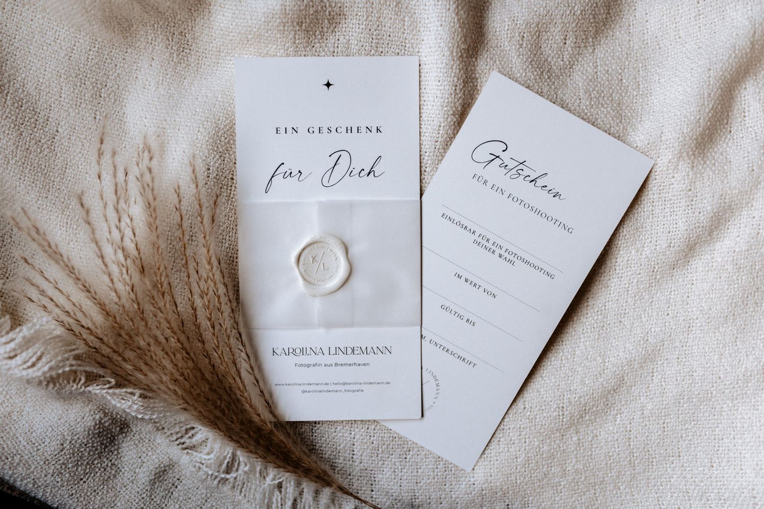Elegant wedding invitation suite with white wax seal on textured fabric.