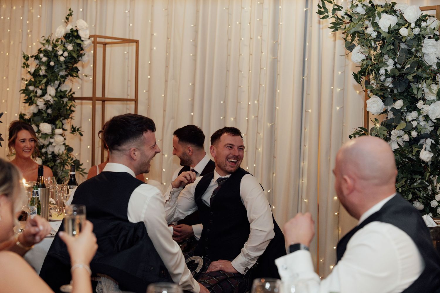 Wedding reception venue decorated with fairy lights and greenery for an elegant evening celebration.