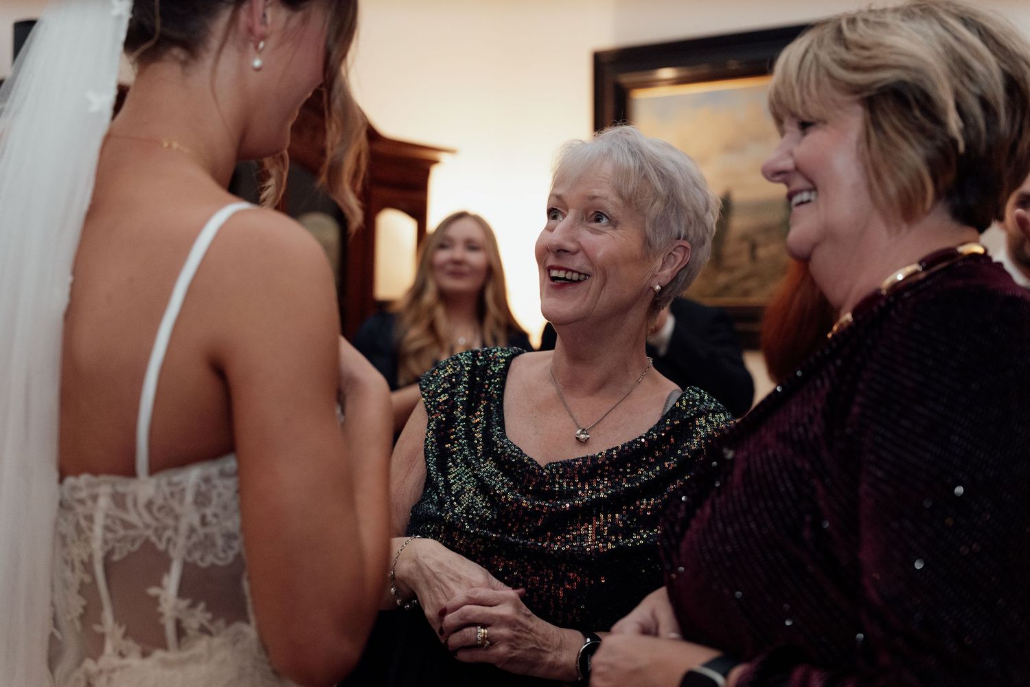 Candid moments captured during an indoor celebration with decorative lighting.