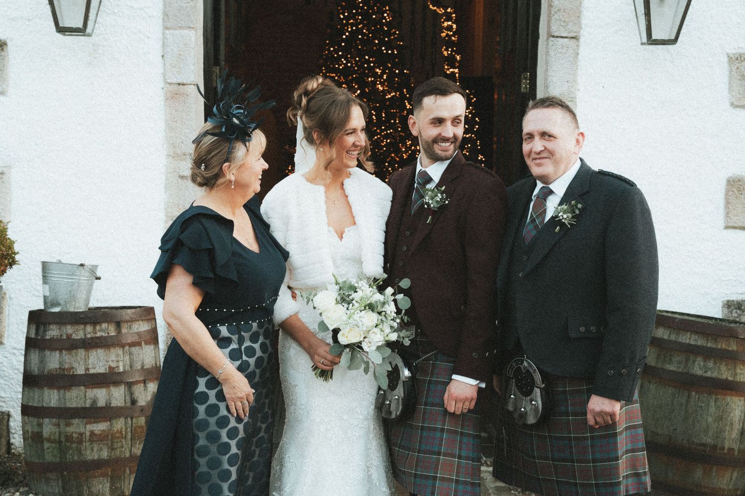 Wedding celebration group shot with Scottish formal wear and white bridal dress.