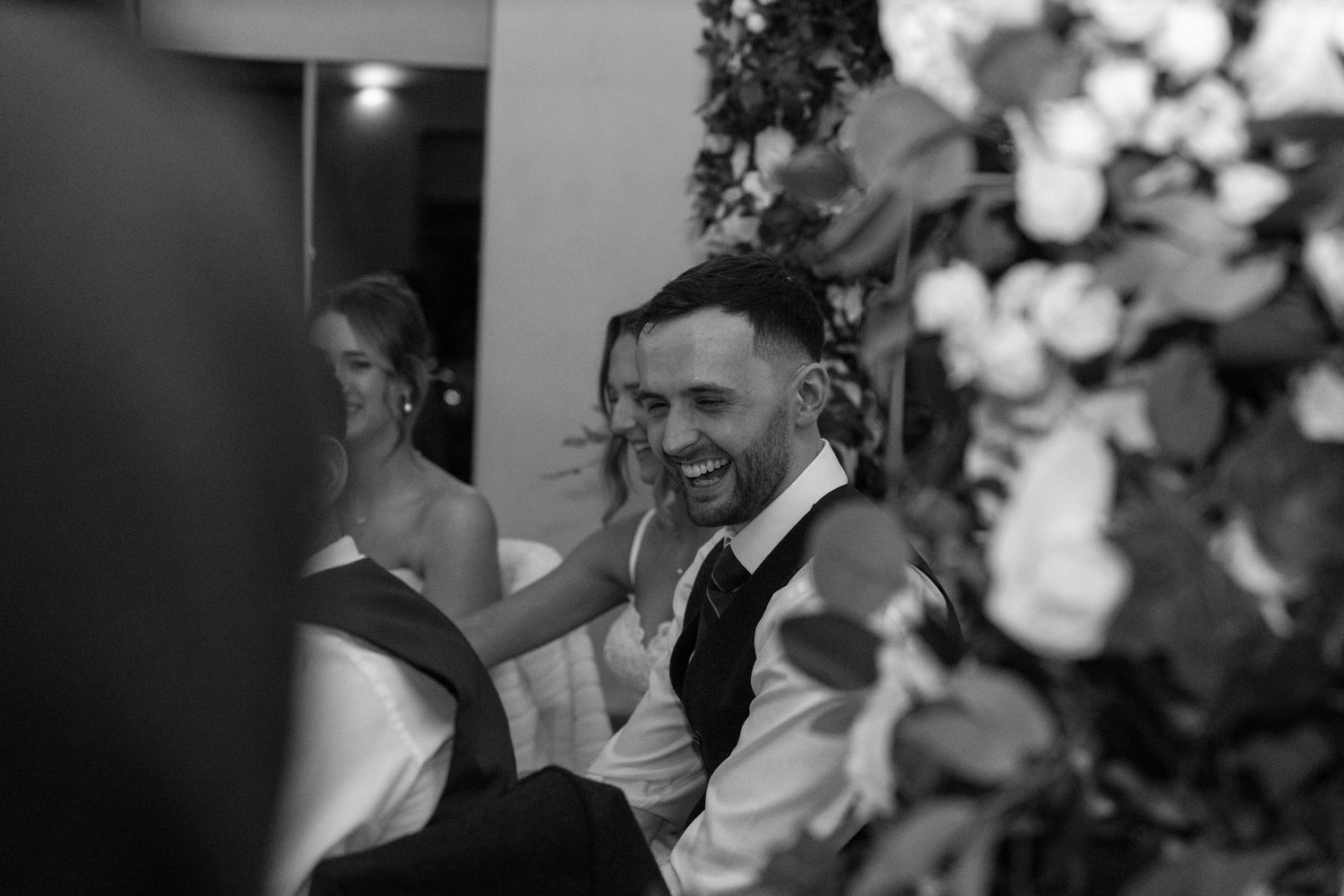 Black and white candid shots capturing joyful moments during a wedding reception.