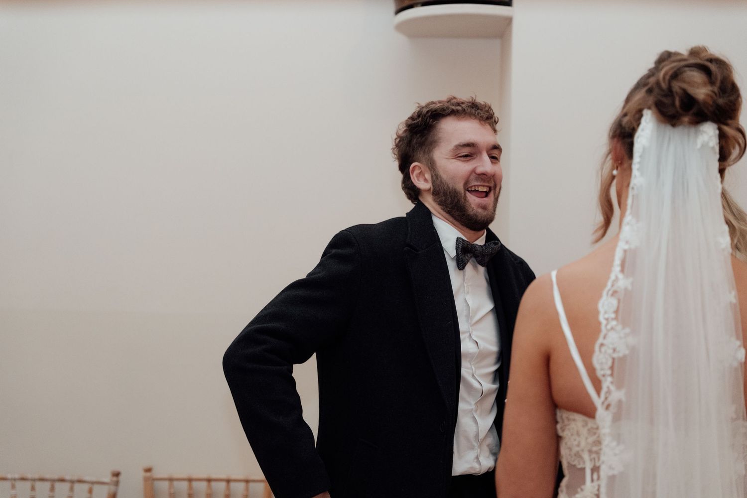 Wedding party members share candid reactions during a joyful celebration moment.