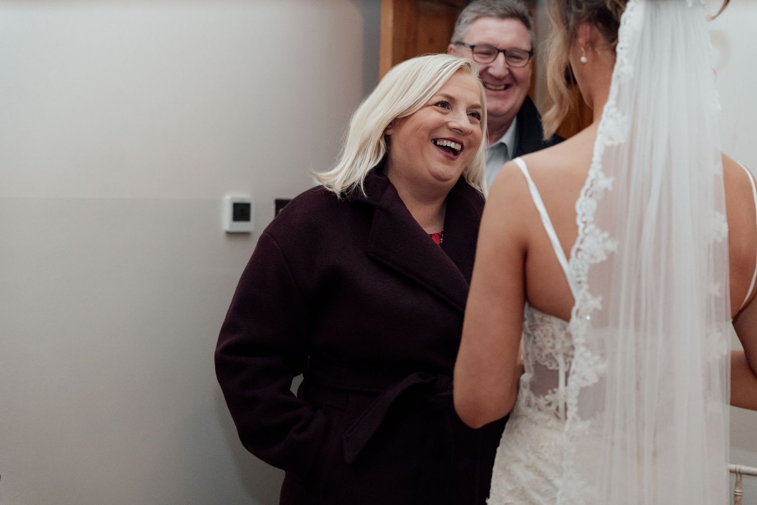 Guests share heartfelt reactions and laughter during a wedding celebration.