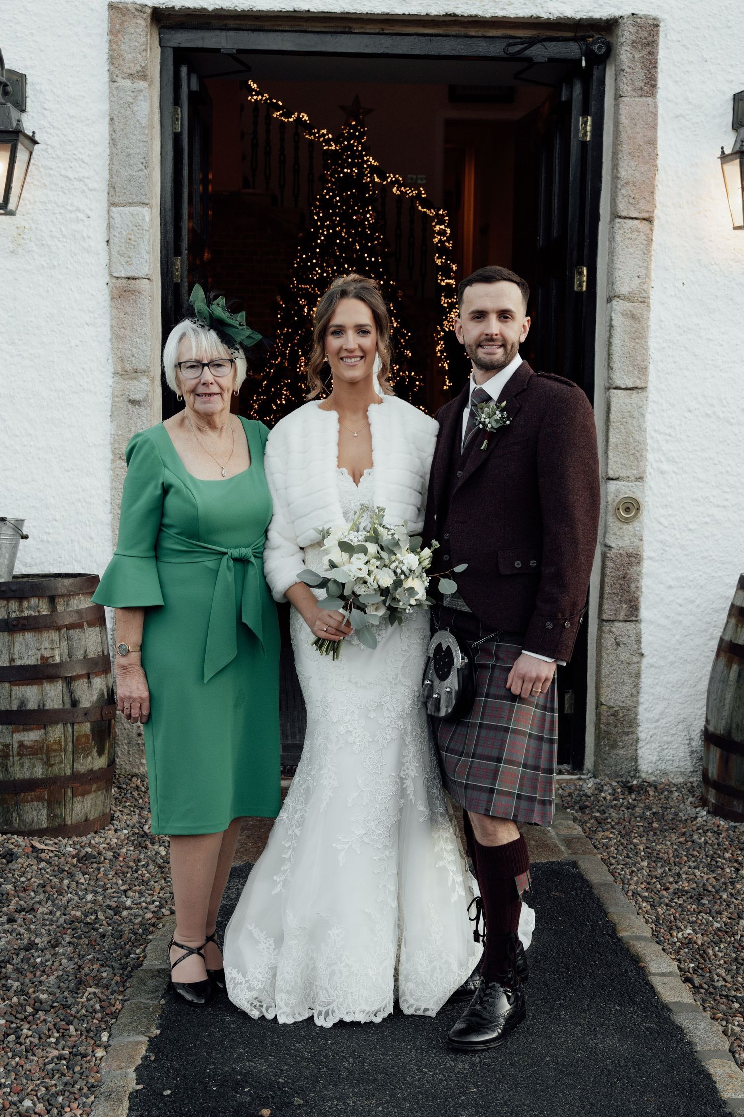 Wedding group photo showing traditional Scottish attire with kilts and formal wear.