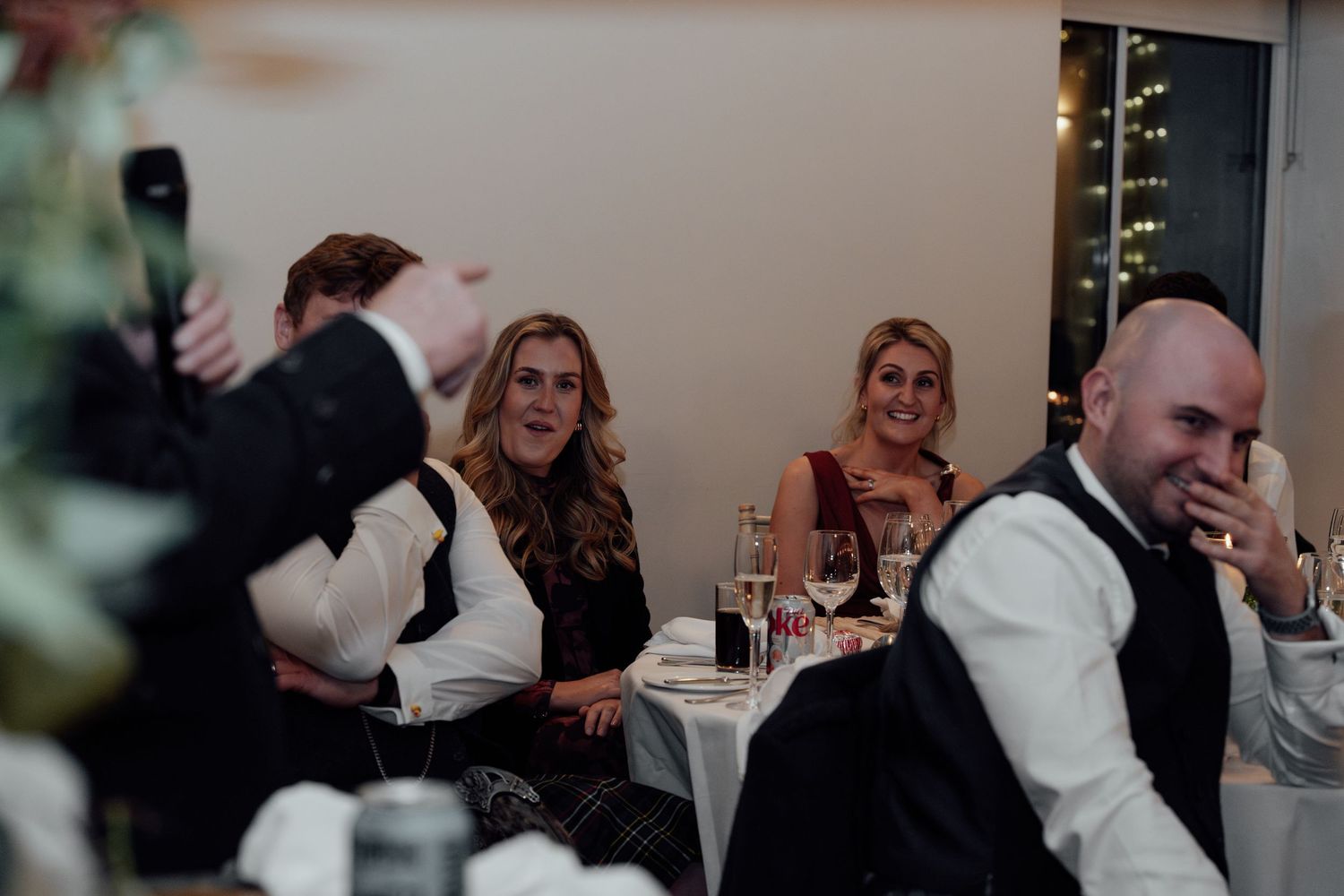 Wedding guests enjoying themselves at a festive reception dinner.
