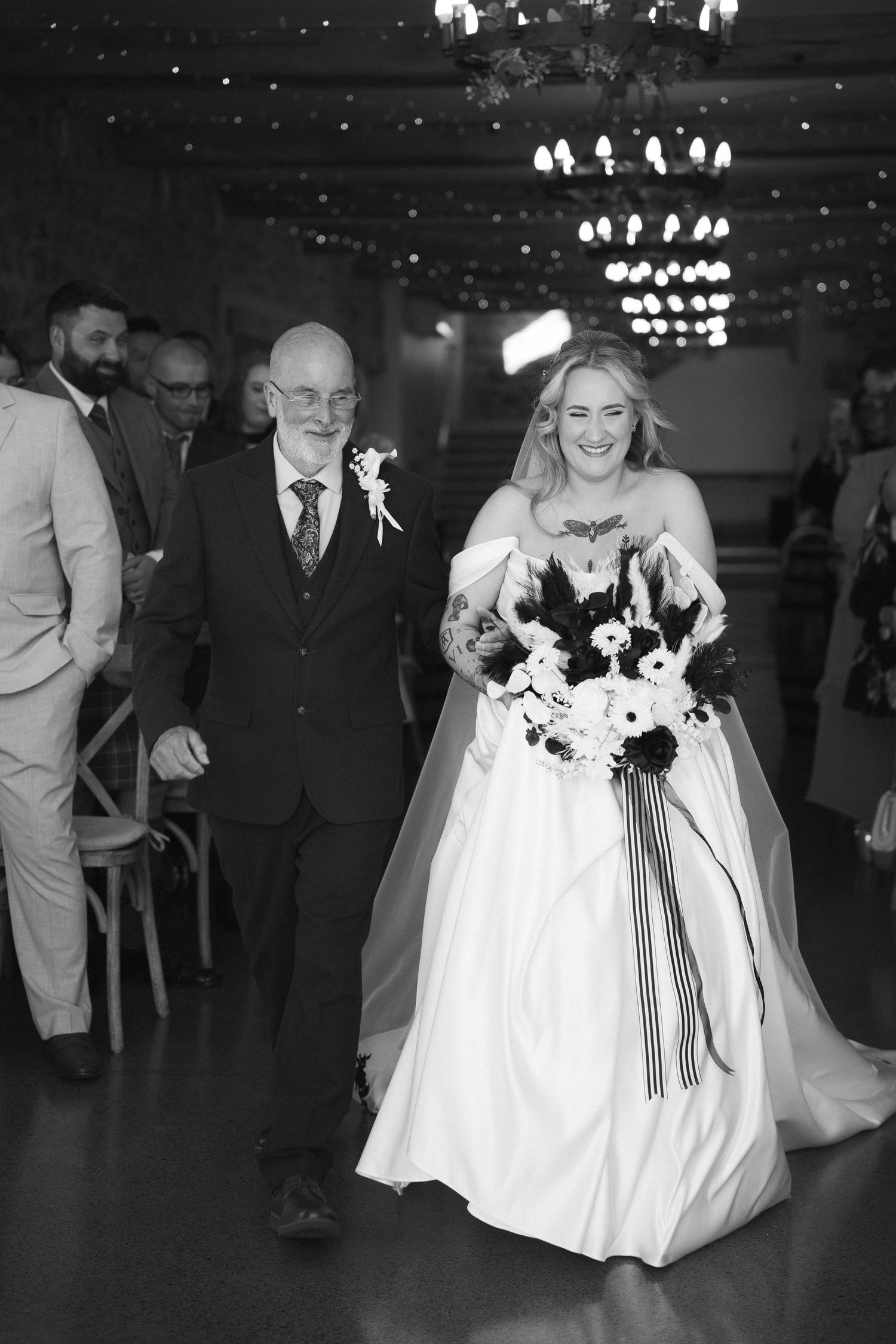 Father walking bride down the aisle in black and white wedding ceremony photo.