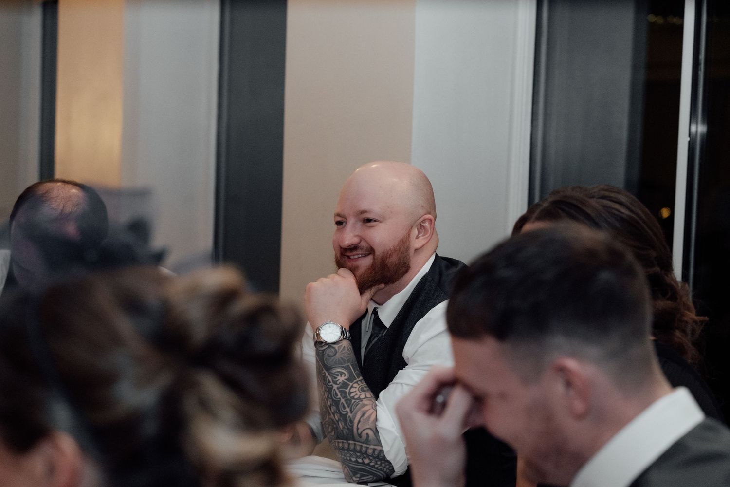 Wedding reception guests sharing laughter during the evening celebration.
