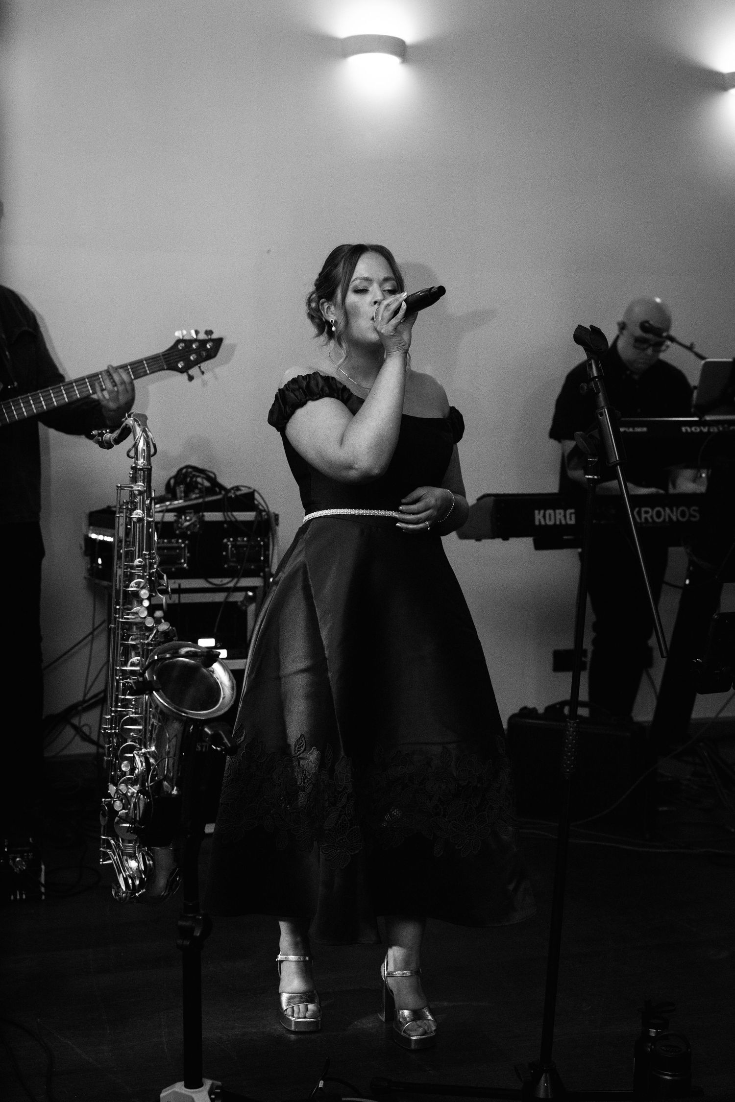 Musicians performing at a wedding reception with instruments and equipment visible.