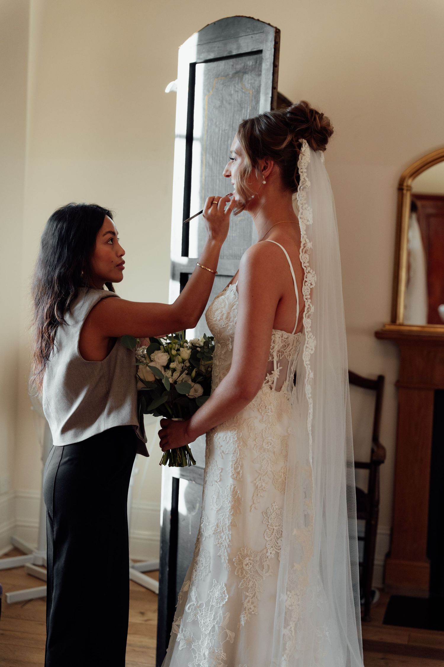 Final wedding dress preparations being made in an elegant dressing room.