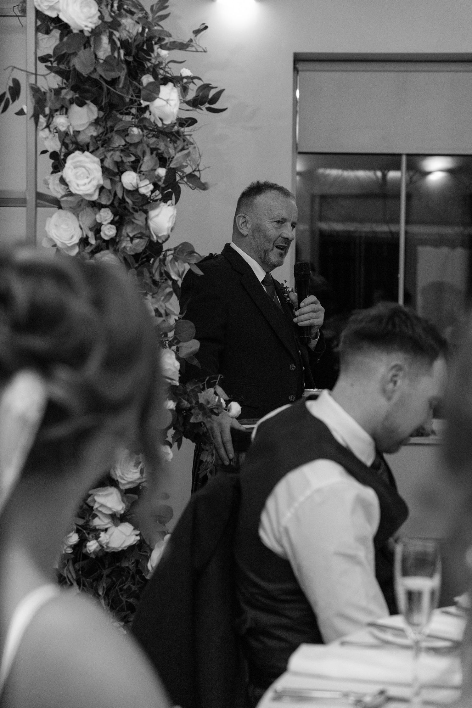 Wedding guests enjoying a formal dinner reception with elegant table settings and decor.