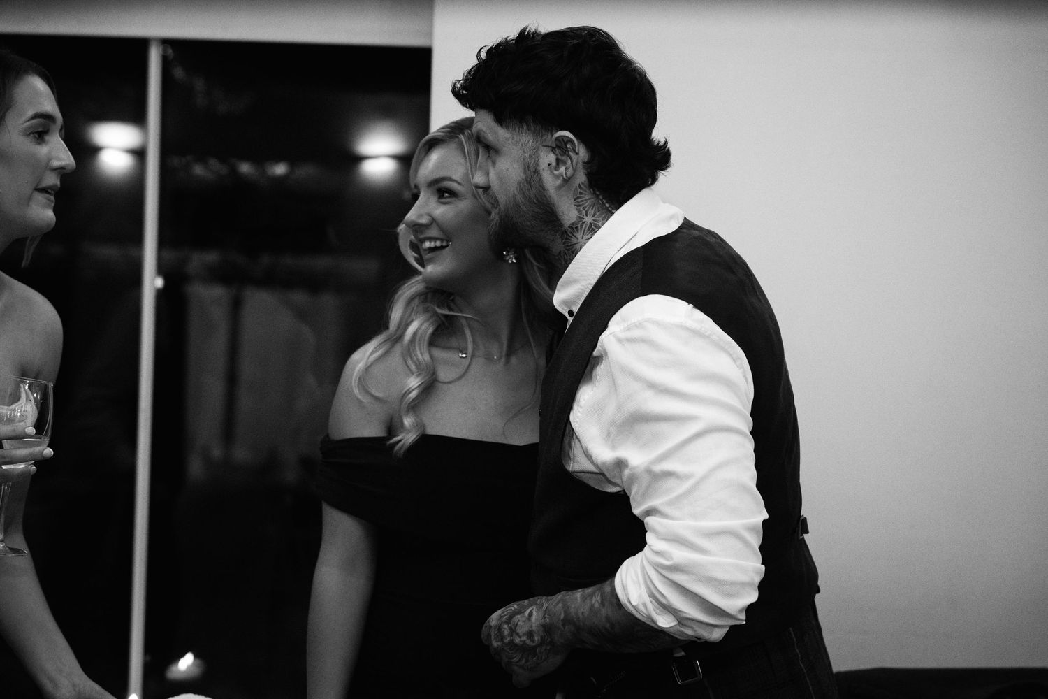 Guests share a candid moment at an elegant black and white wedding reception.