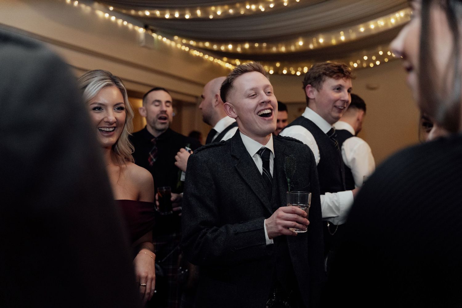 Candid moments of celebration captured during an evening wedding reception.