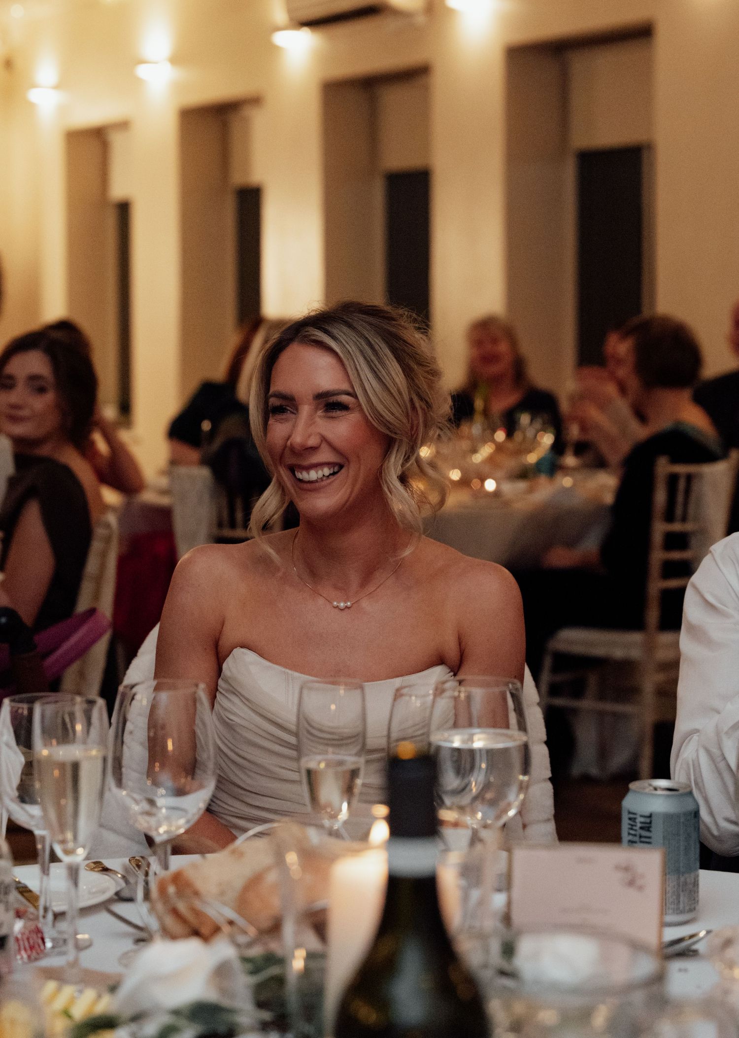 Wedding reception dinner scene with guests laughing and enjoying the celebration.