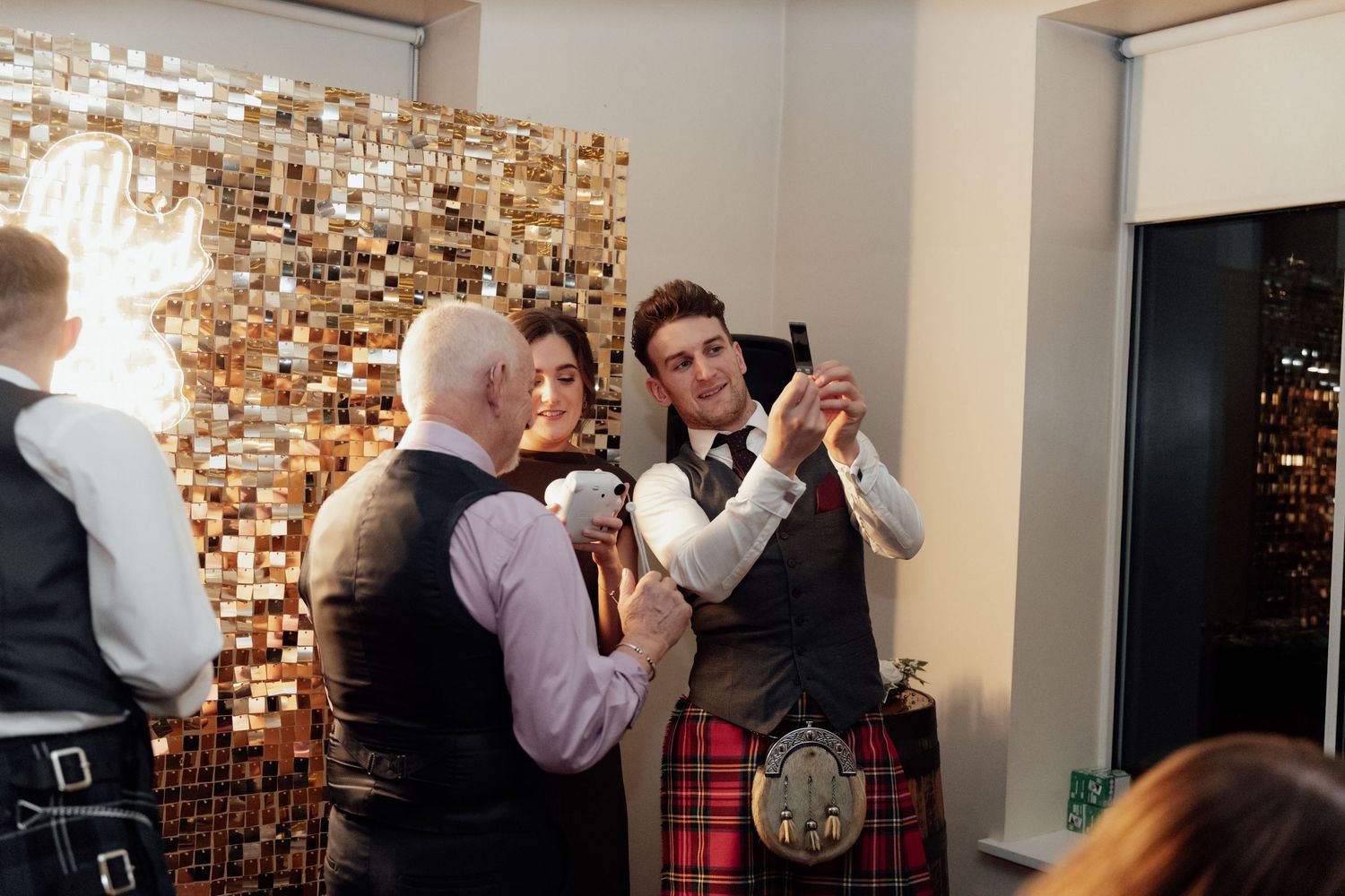 Reception venue features decorative wall lighting and guests mingling in formal attire.
