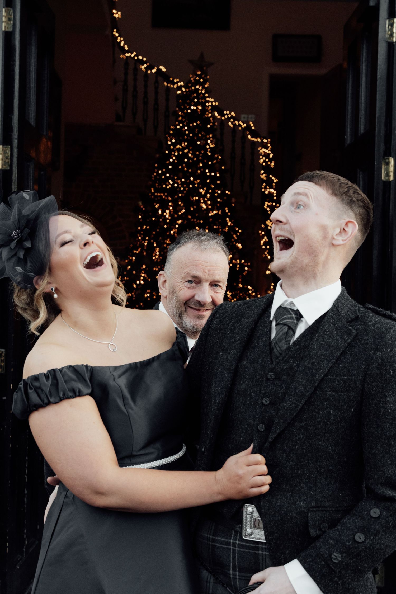 Candid wedding party photos showing laughter and joy outside venue with Christmas lights.