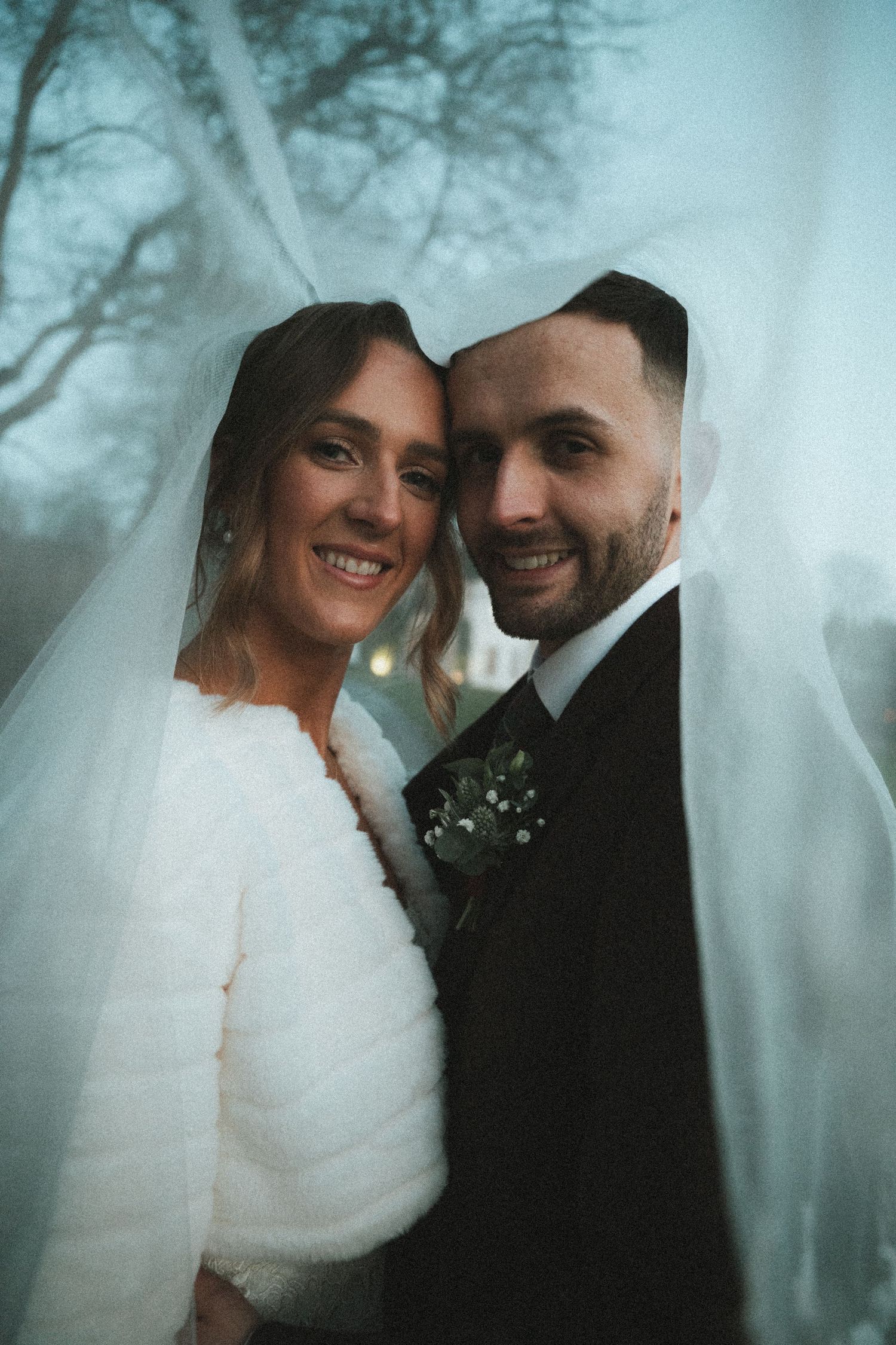 Ethereal wedding portraits with a dreamy blue tint showing intimate moments between the newlyweds.