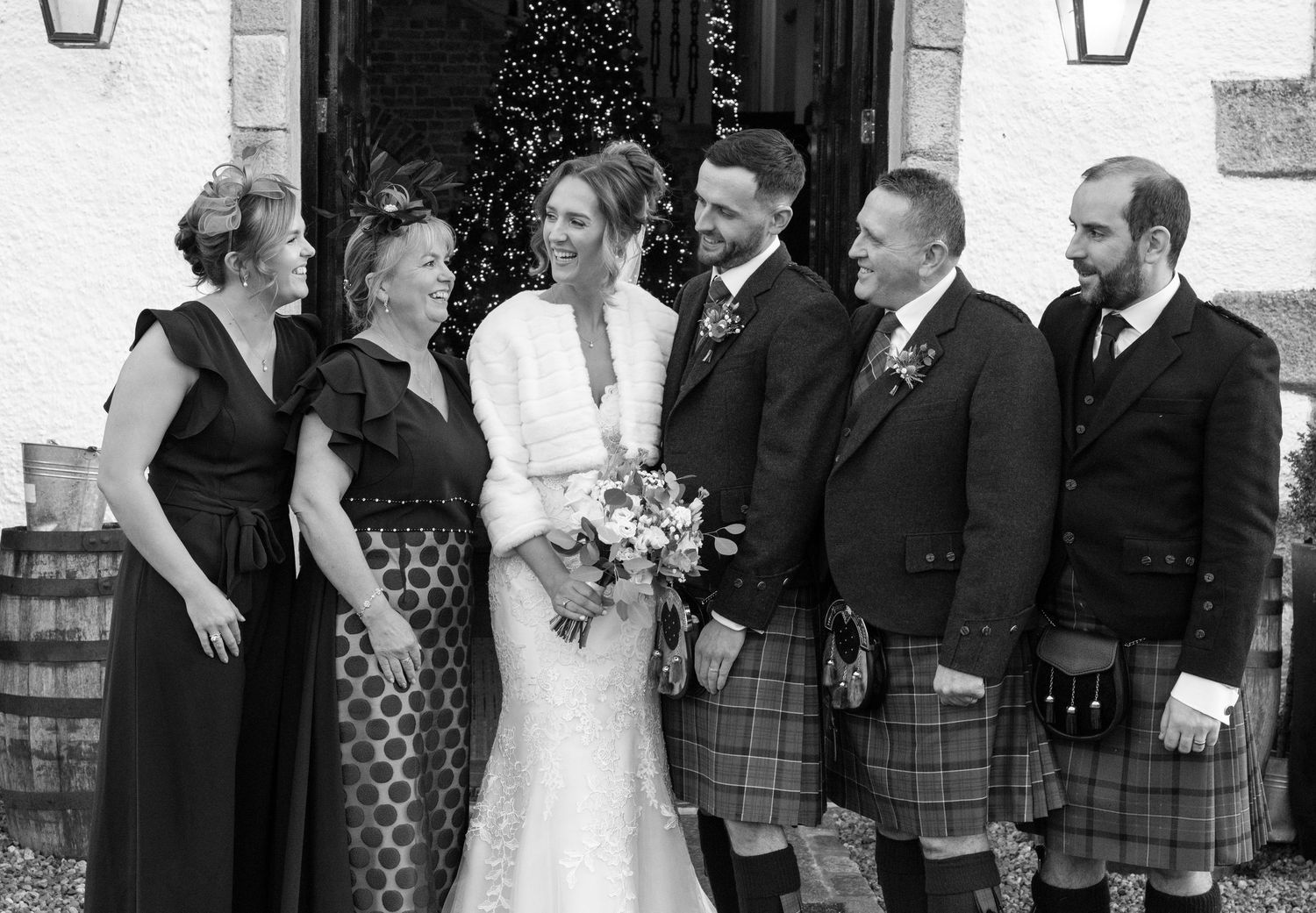 Black and white photo of wedding party members in Scottish formal wear.