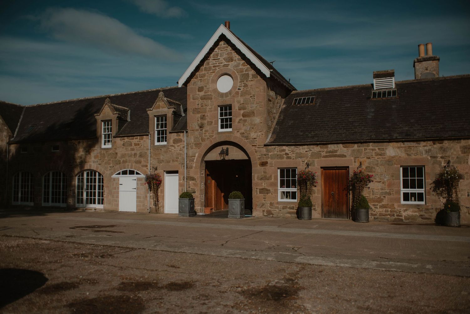 Panoramic view of a rustic stone building complex with traditional architecture.