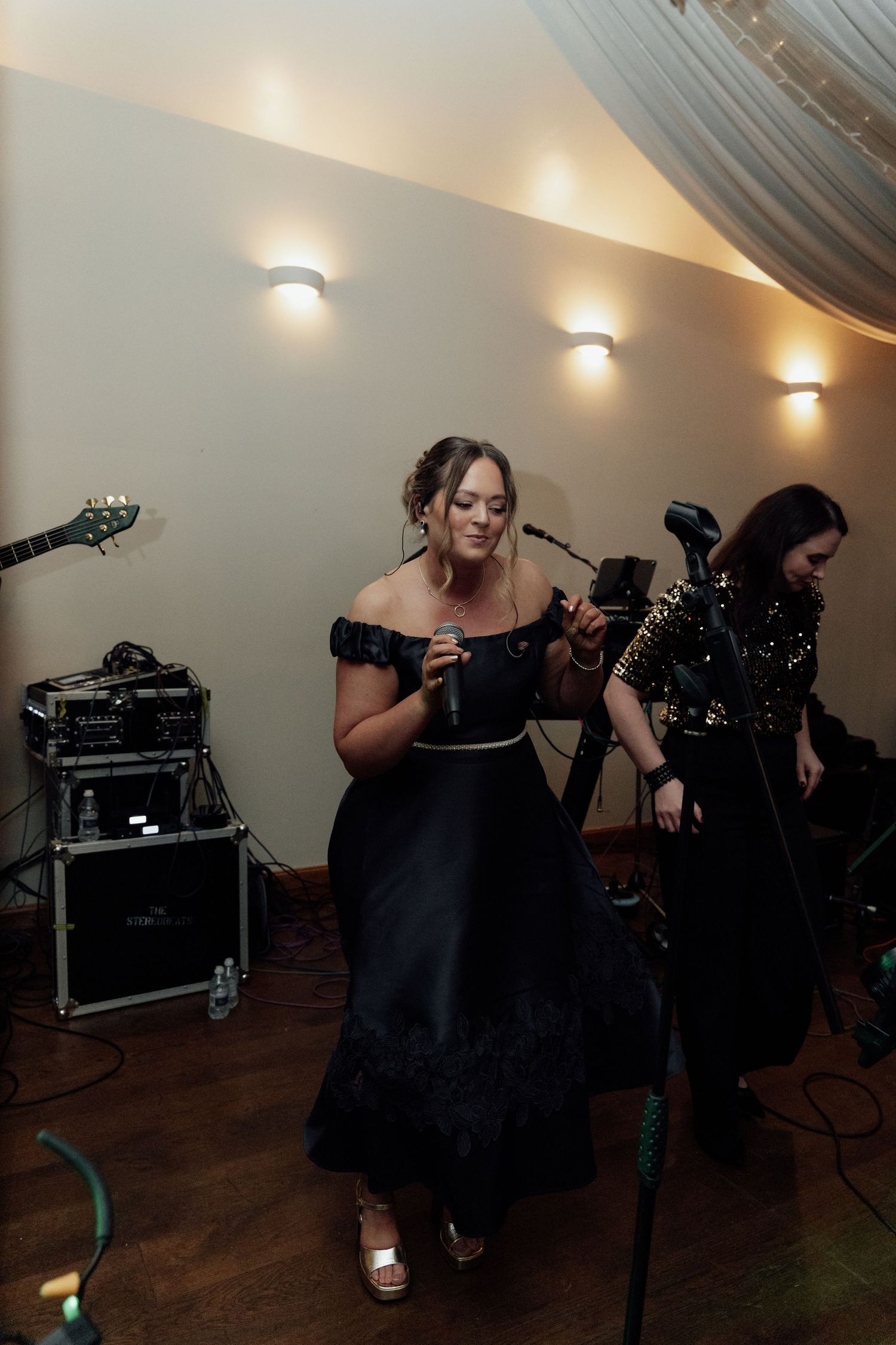 Band members in black attire setting up equipment for wedding performance.