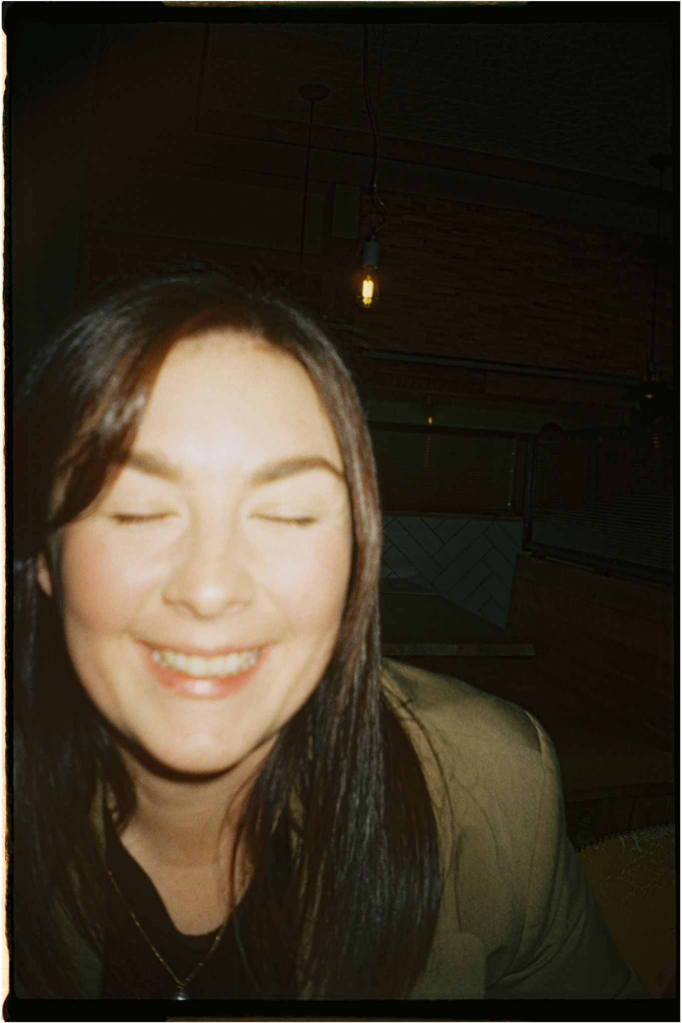 A close-up flash photo showing a warm, genuine smile.