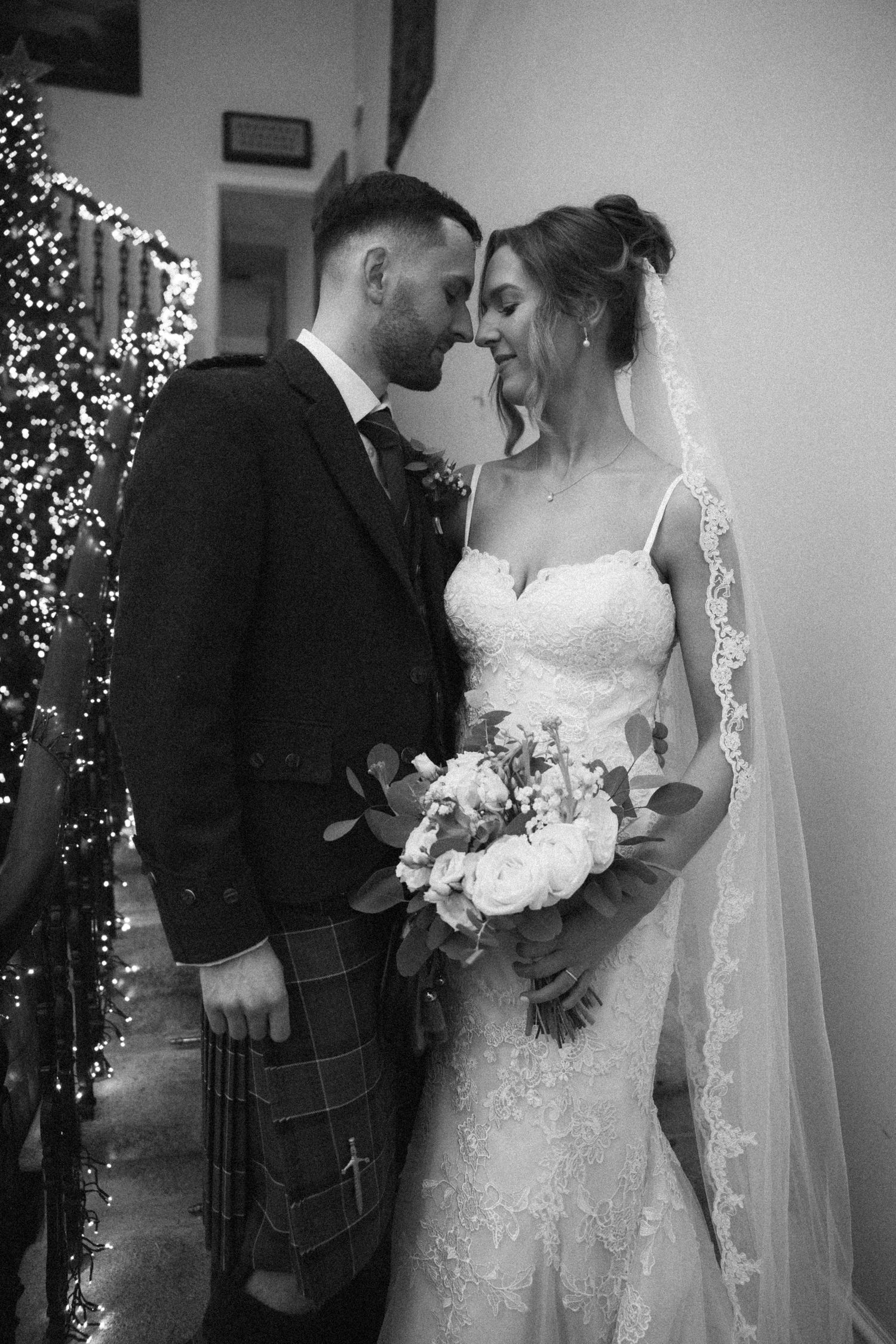 Black and white intimate wedding portrait with bride holding white bouquet.