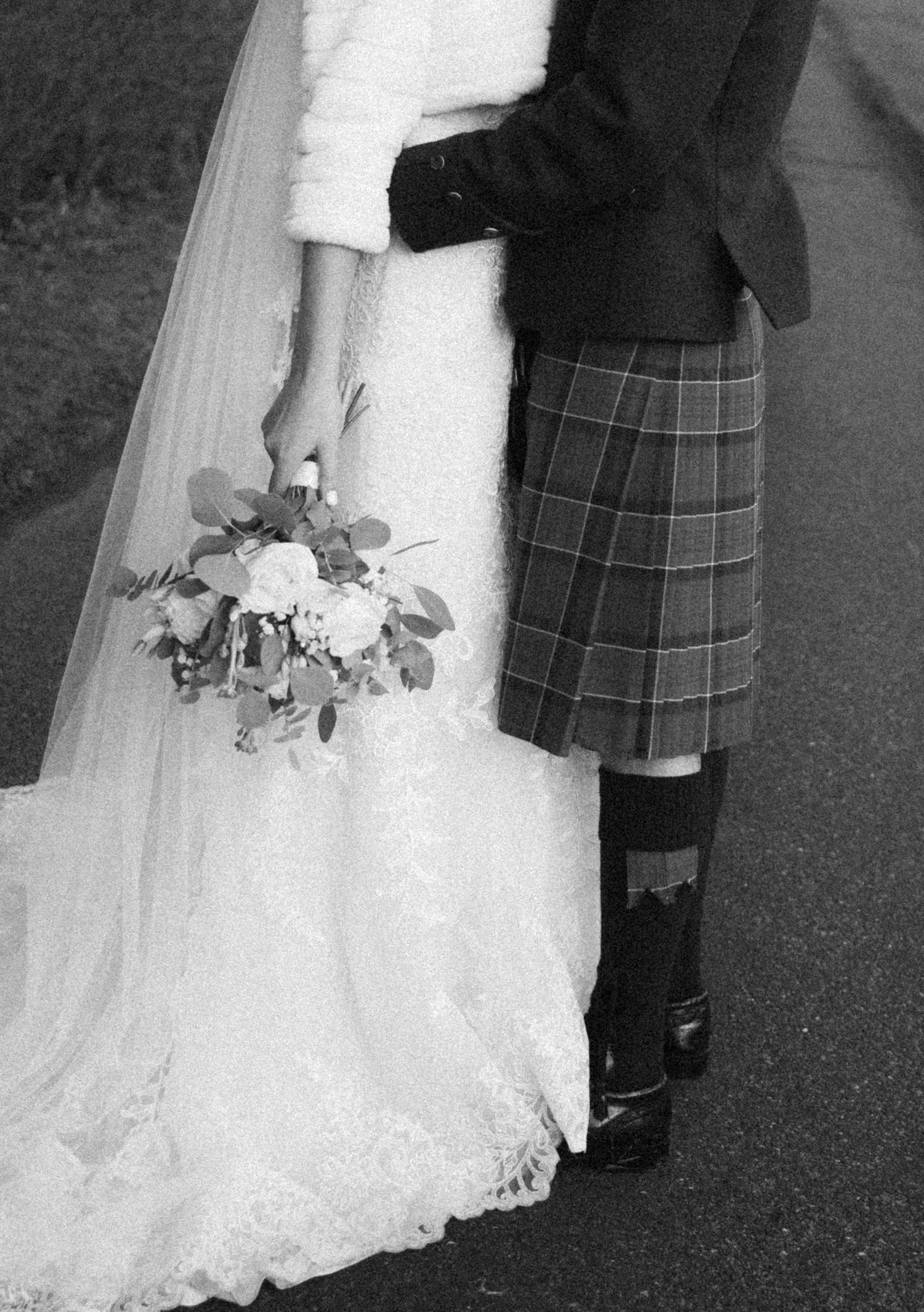 Detail shots of wedding attire showing white bridal gown and traditional plaid kilt during outdoor ceremony.