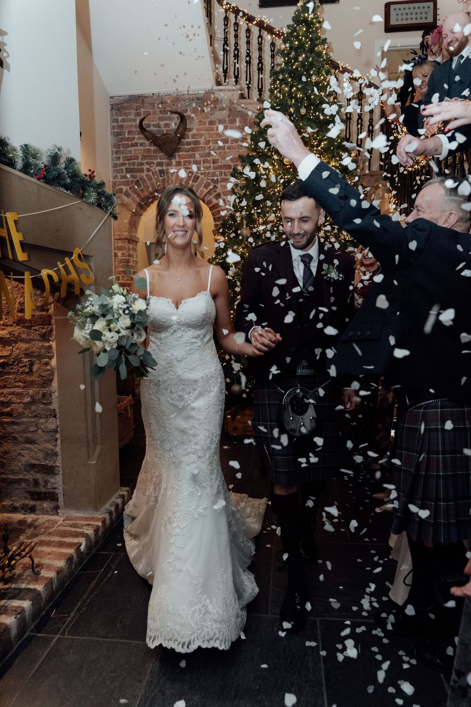 Festive winter wedding scene with confetti and Christmas decorations in elegant venue.