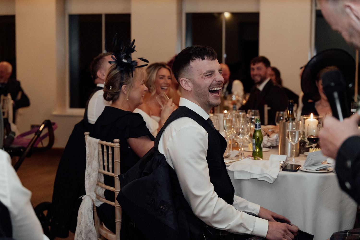 Candid moments of laughter and joy during a wedding reception dinner party.