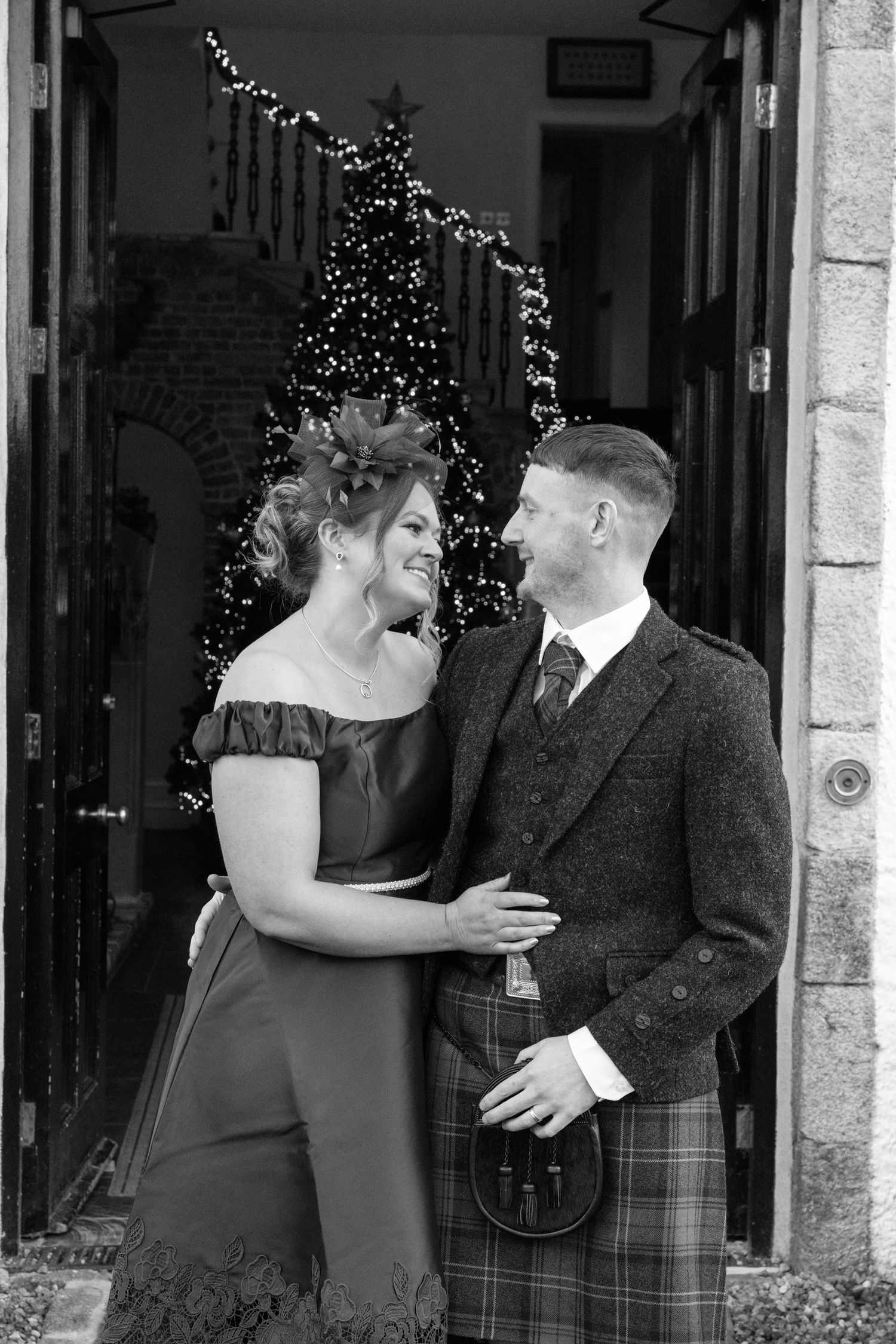 Black and white wedding photos showing candid moments and laughter outside stone building.