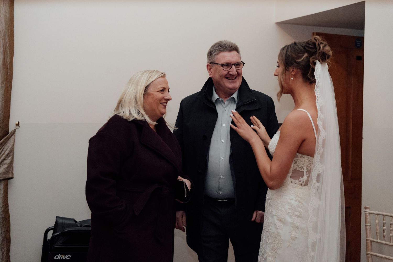 Wedding guests mingle and socialize during an indoor reception event.