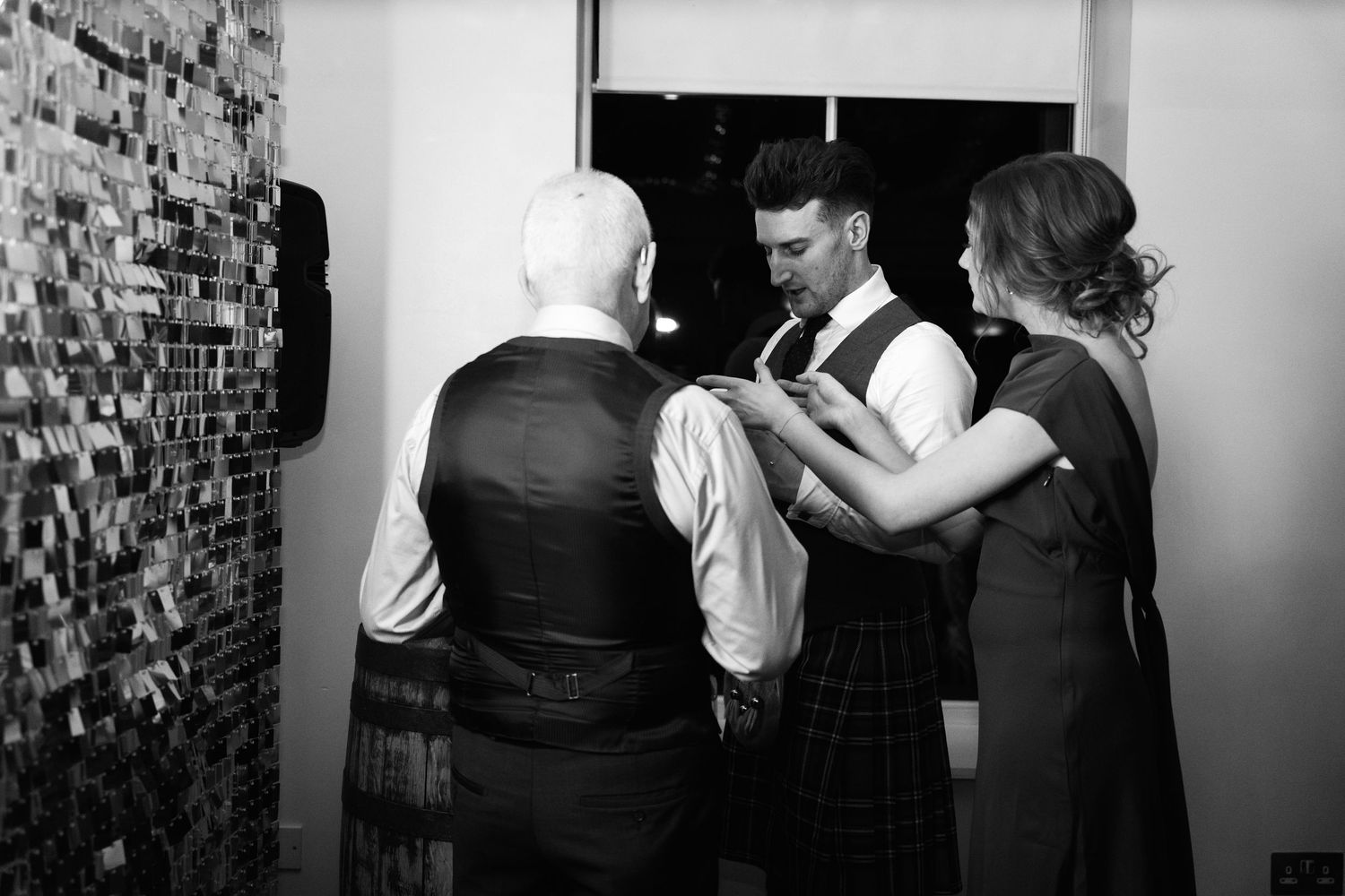 Black and white shot of wedding guests dancing and celebrating together.