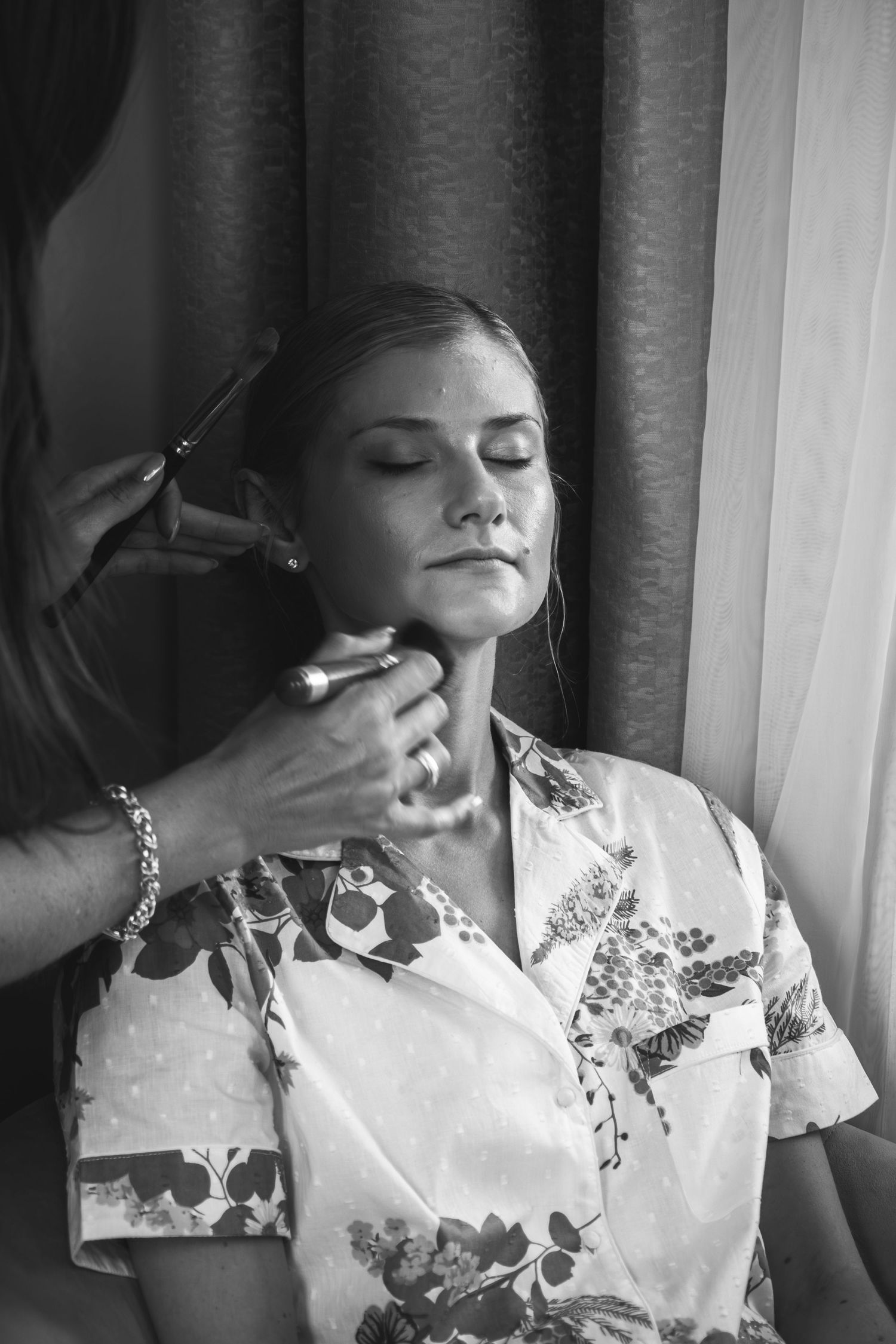 Artistic black and white photo sequence showing someone in floral dress adjusting their collar and hair near curtained window.
