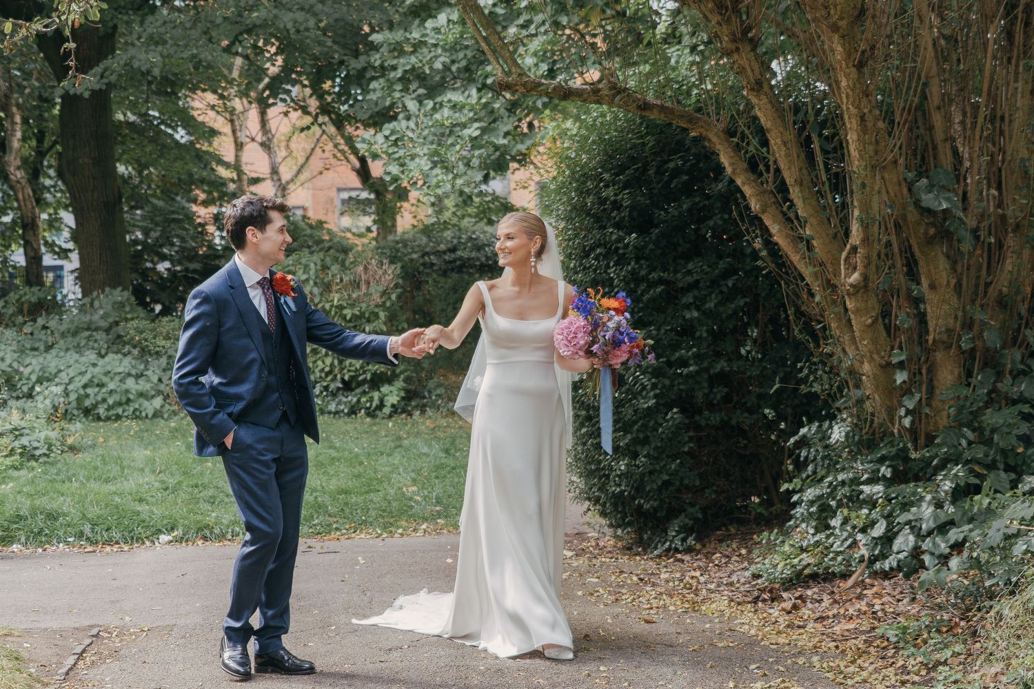 A couple shares a romantic moment together in a lush garden setting during their wedding day.
