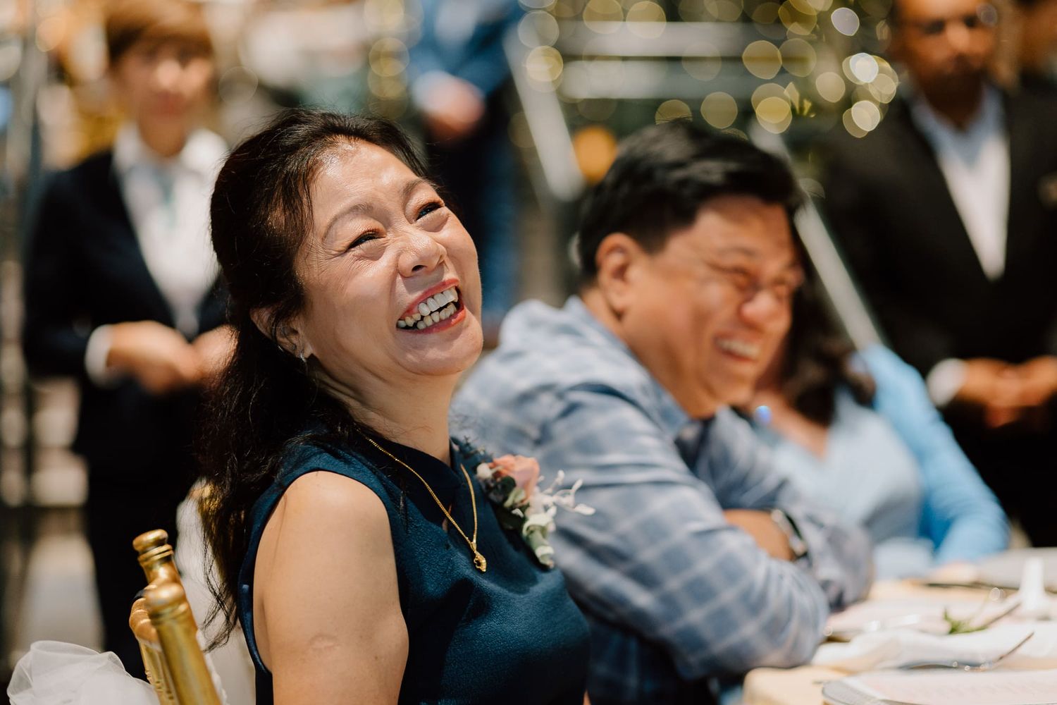 People enjoying a wedding reception filled with laughter and joy during dinner service.