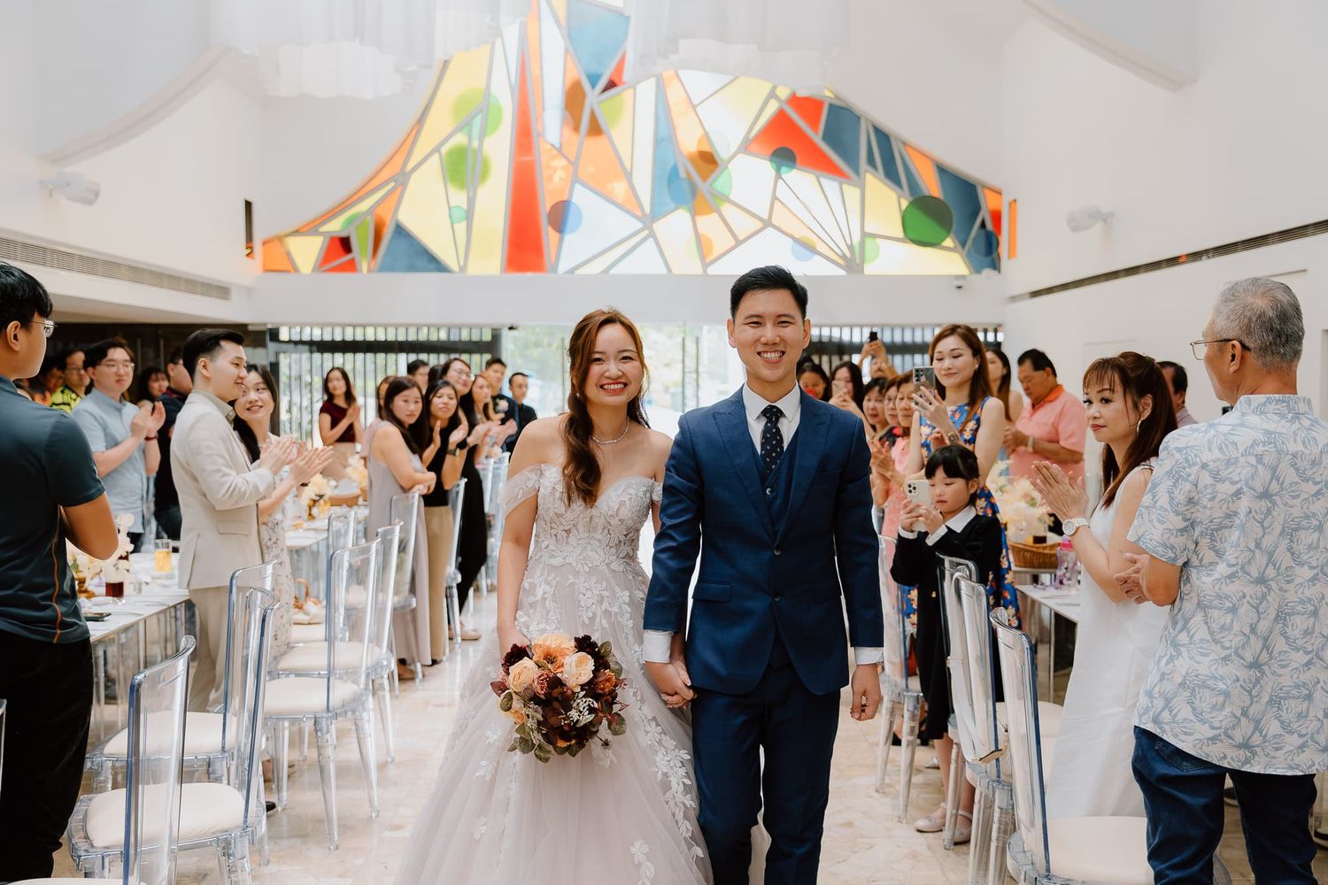 Elegant wedding venue with modern decor and guests mingling in a bright space.