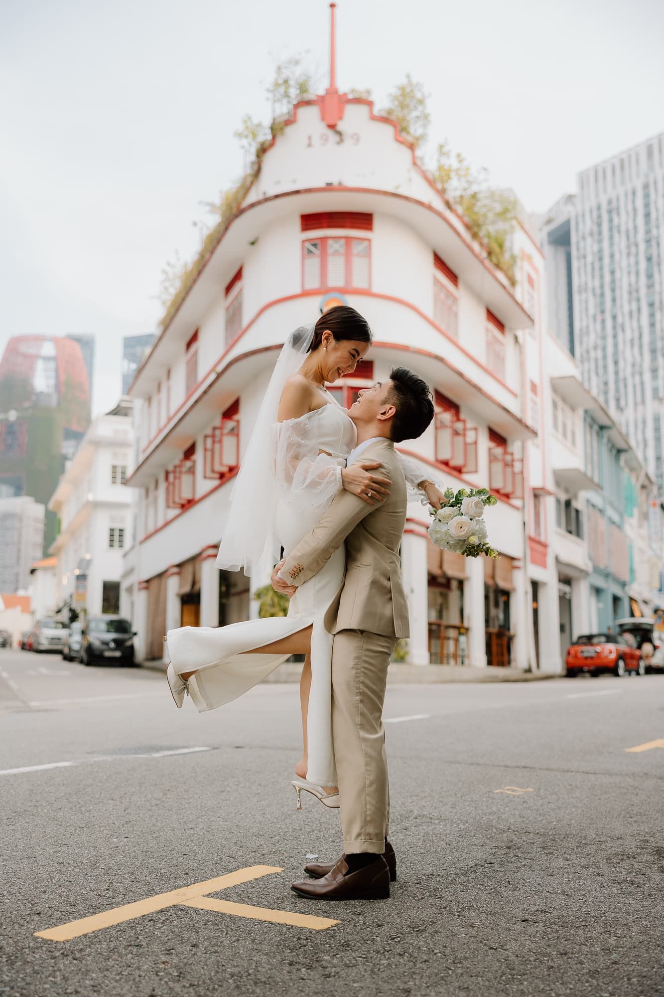Candid dance moves captured on street with vintage architecture backdrop.