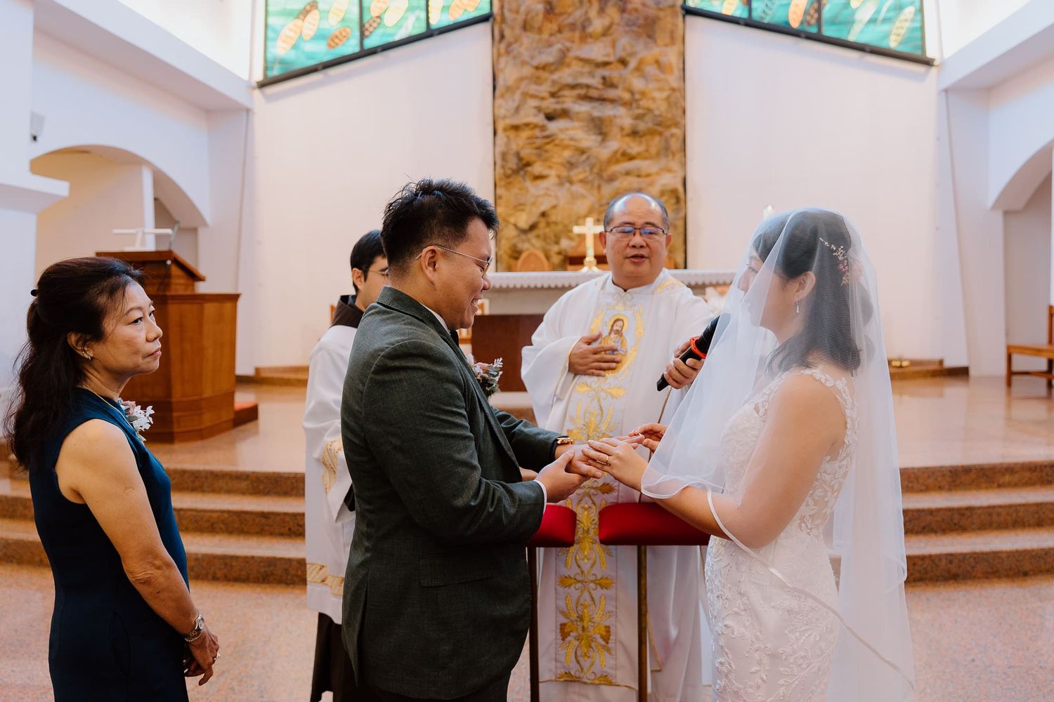 Wedding guests socialize and raise glasses to toast during an indoor reception celebration.