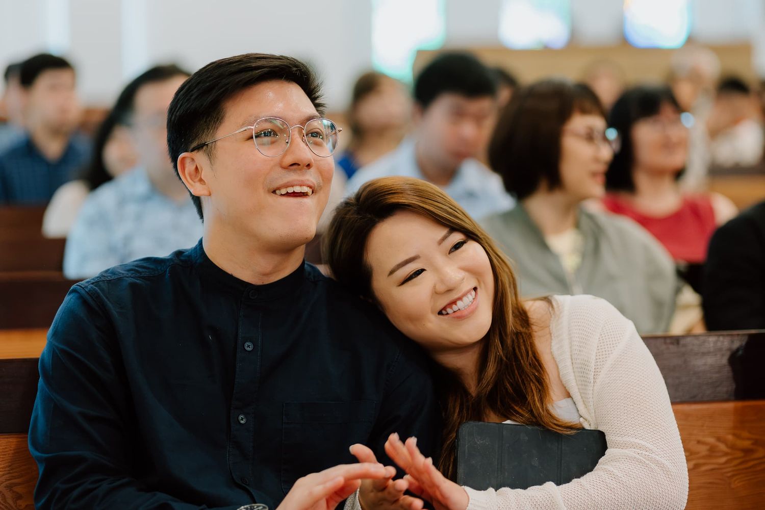 Happy couple shares joyful moment together in church pew.