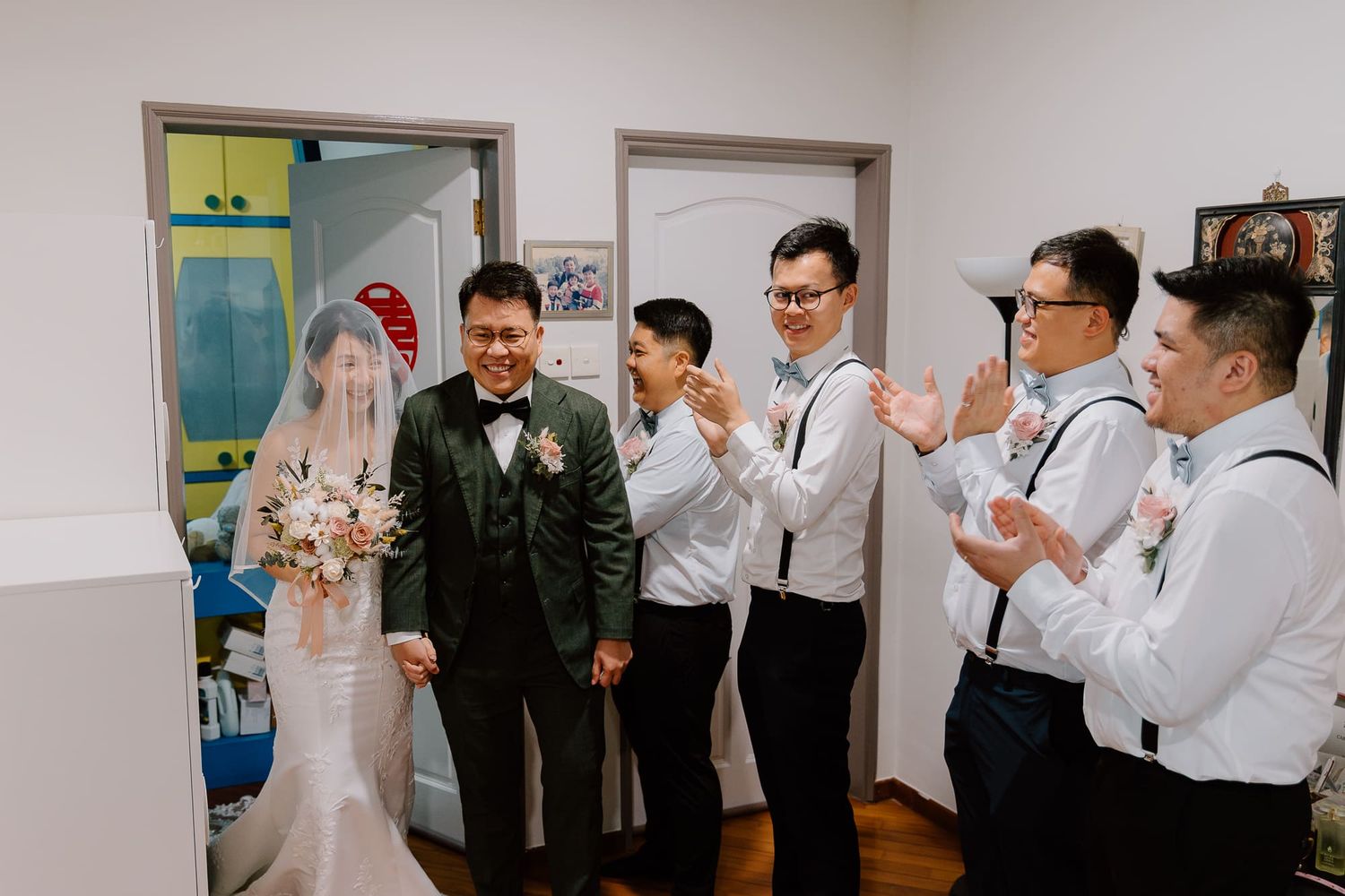 Wedding party celebrates with a toast and drinks at an indoor reception event.