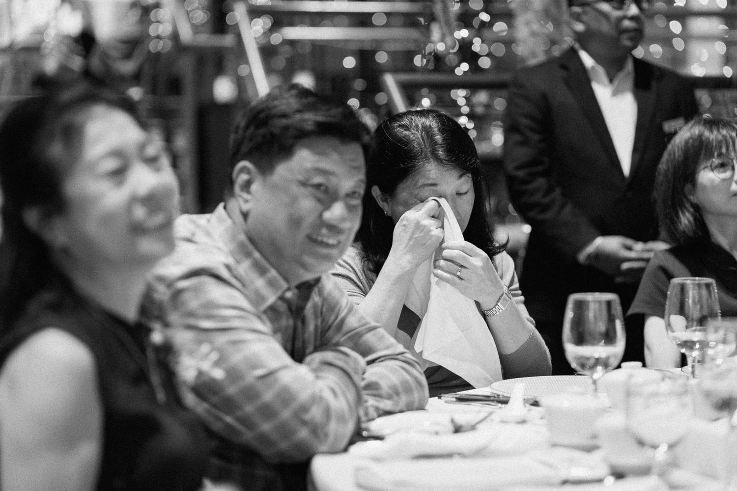 Black and white photographs show multiple people enjoying dinner and conversation at tables during a formal event.