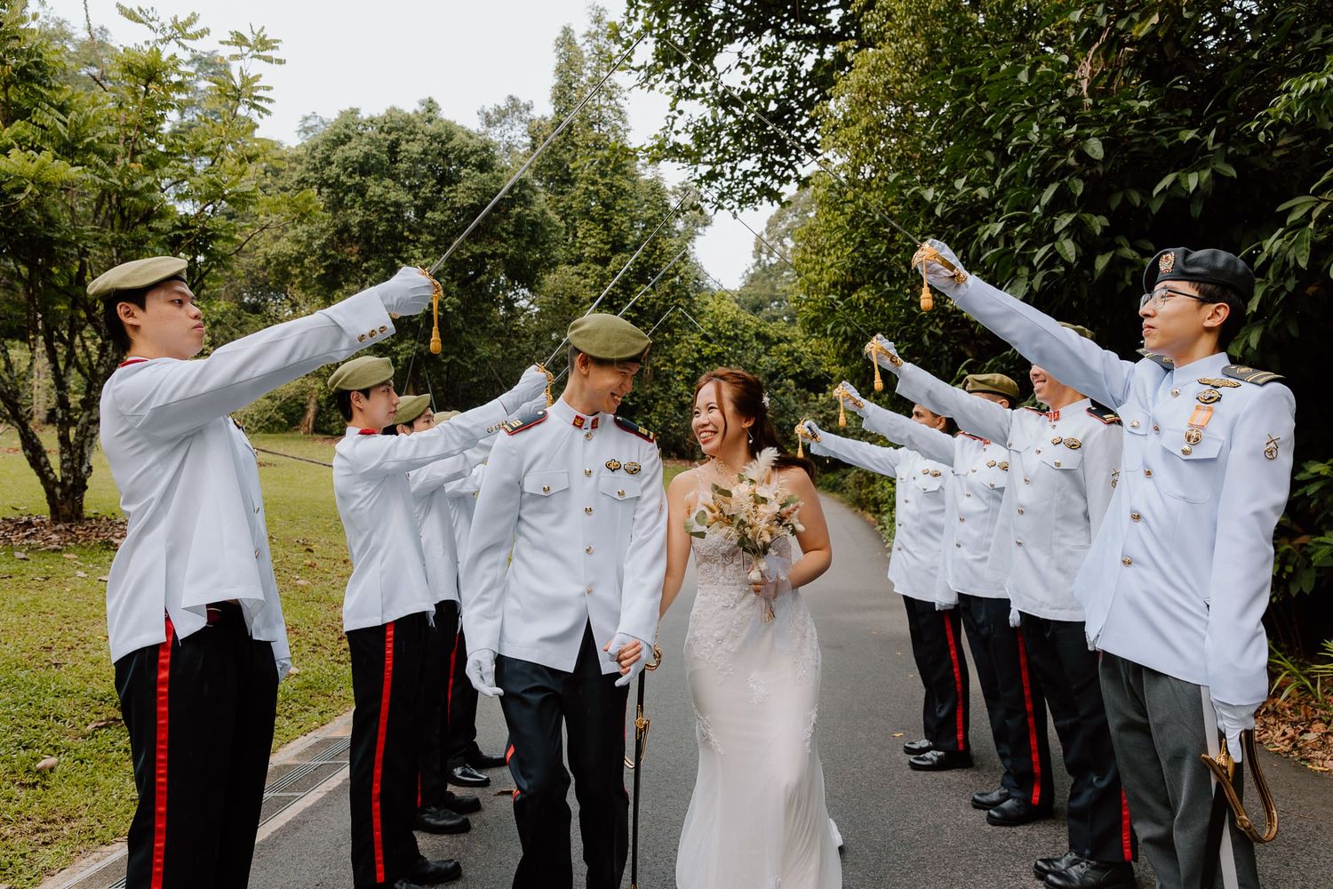 Military ceremony participants perform a traditional saber arch tunnel formation during a formal outdoor ceremony.