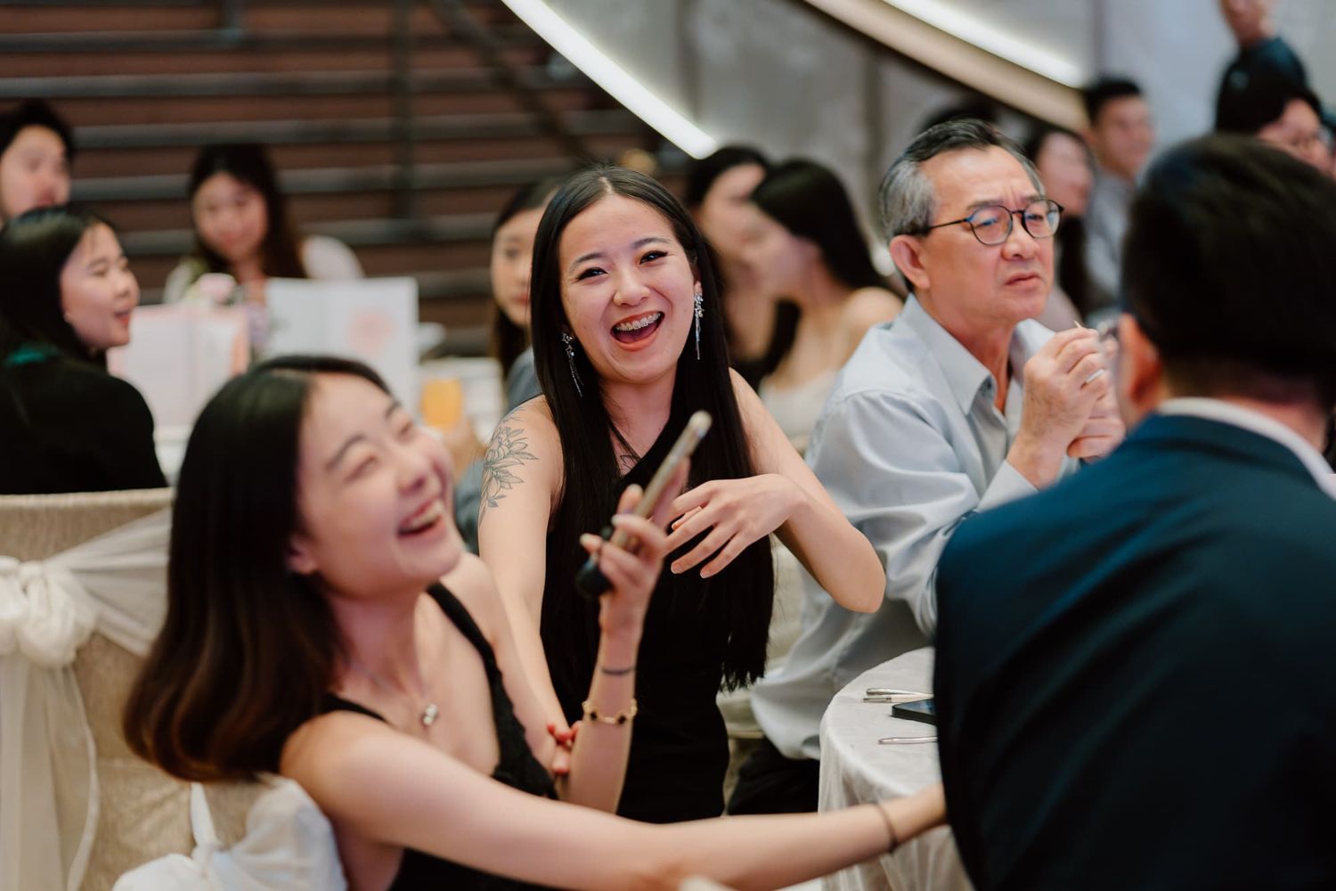 Wedding guests having fun and laughing during a reception celebration.