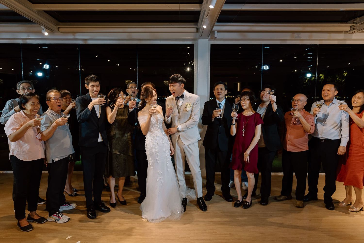Wedding guests and wedding party posing together for a celebratory group photo during the reception.