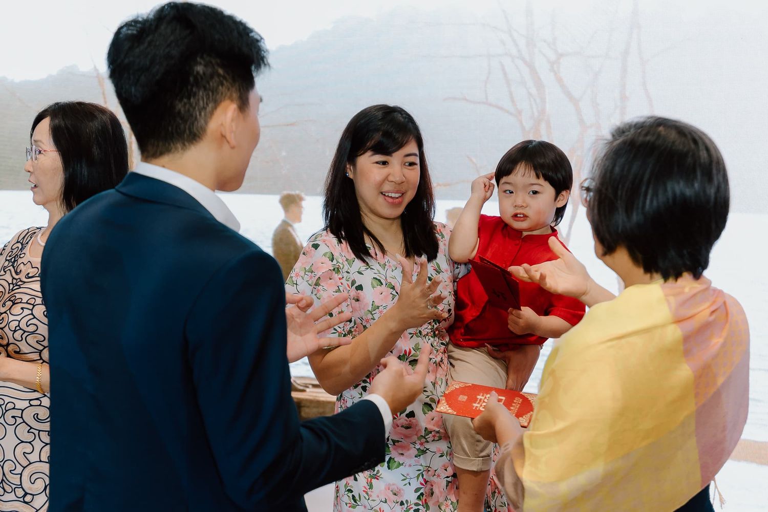 A group of people smile and toast with drinks at an elegant gathering.