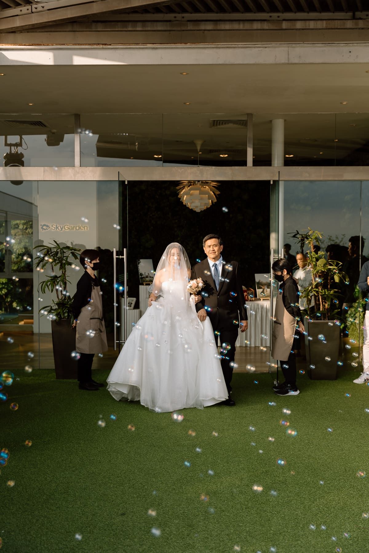 Indoor wedding reception on artificial grass with floating bubble decorations.