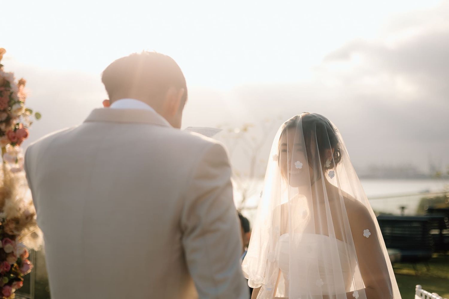 Golden hour wedding portrait of a couple silhouetted against a sunset sky.