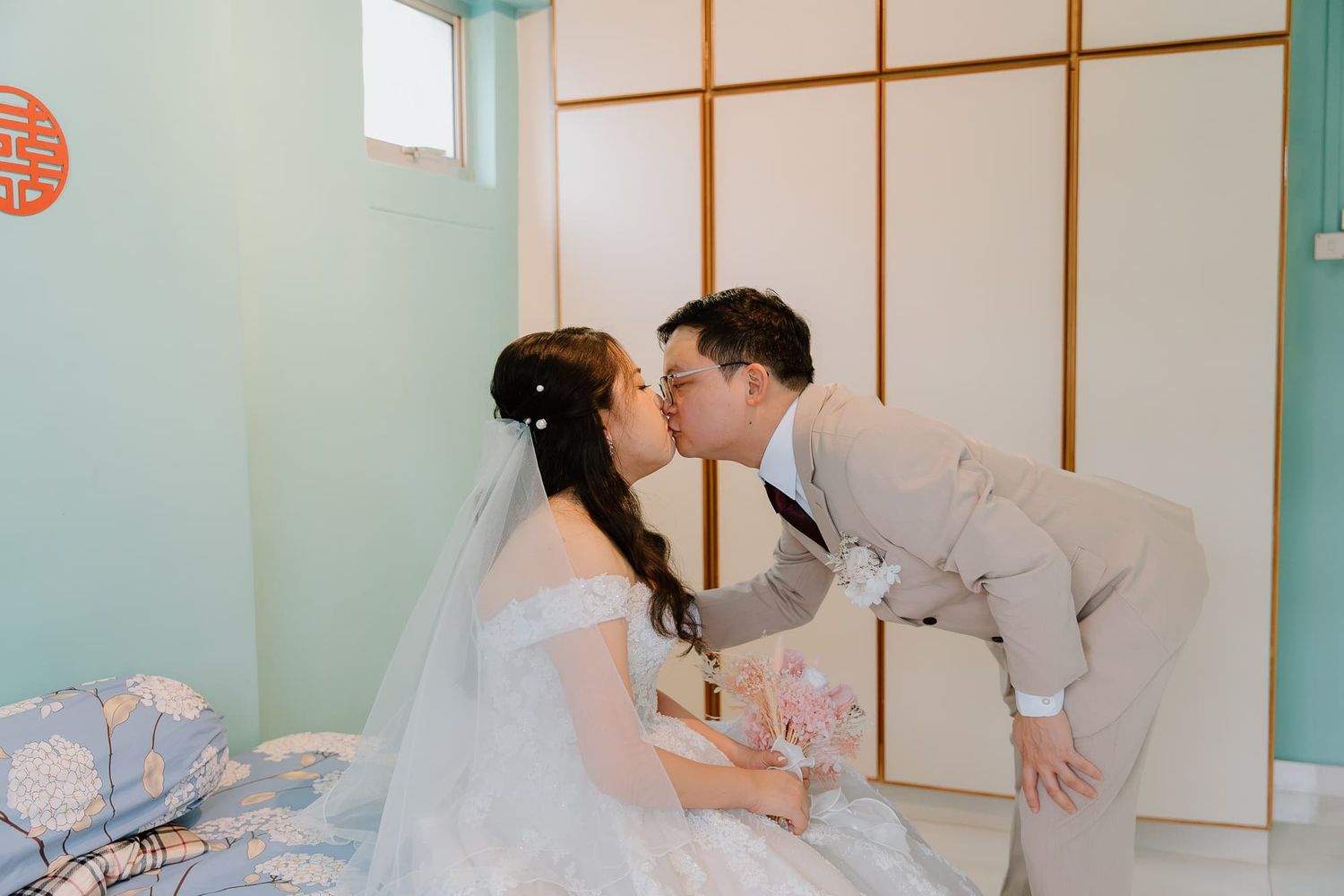 Wedding preparations in a room with mint green walls and traditional Asian decor elements.