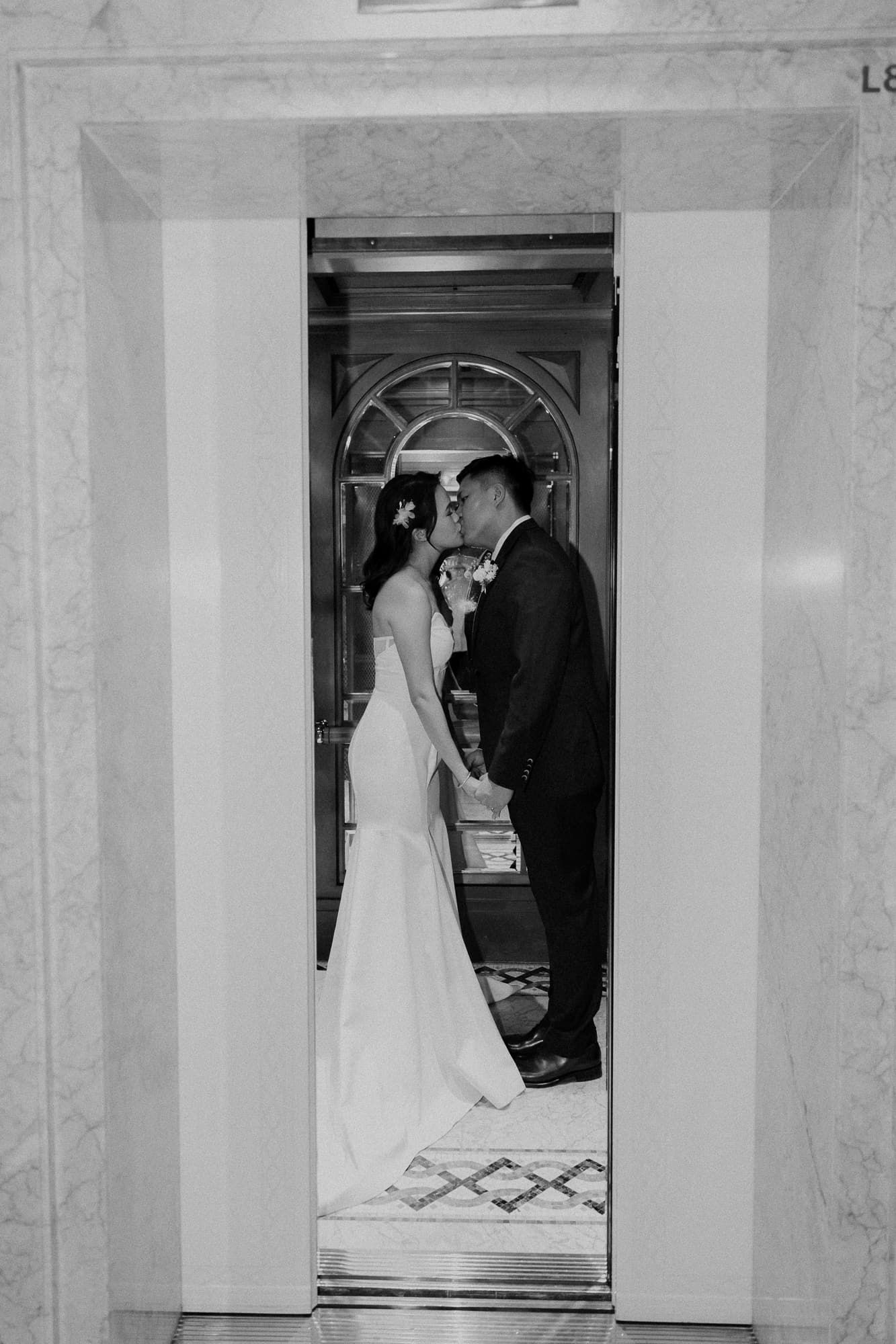 Elegant marble hallway with arched doorways capturing wedding moments in black and white.