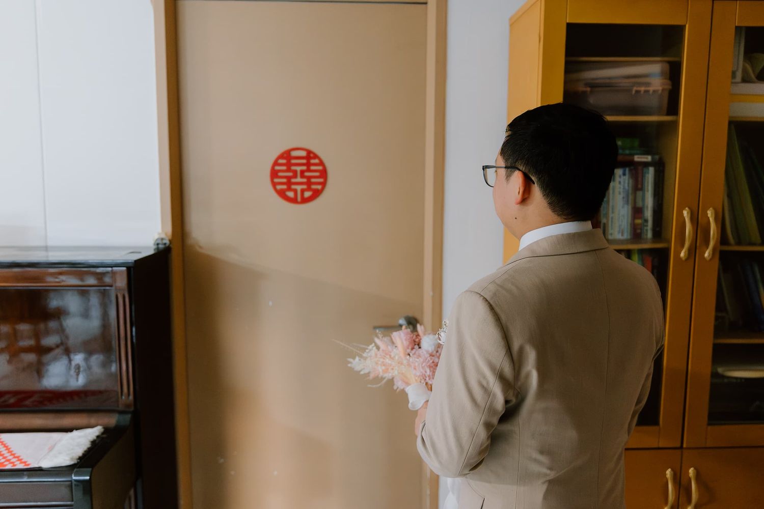 Living room interior with wooden furniture and traditional Chinese double happiness symbol.